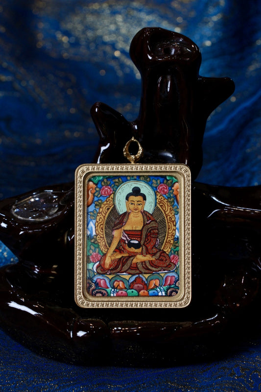 Shakyamuni Buddha thangka amulet used in Tibetan Buddhism for blessings, mindfulness, and spiritual protection.