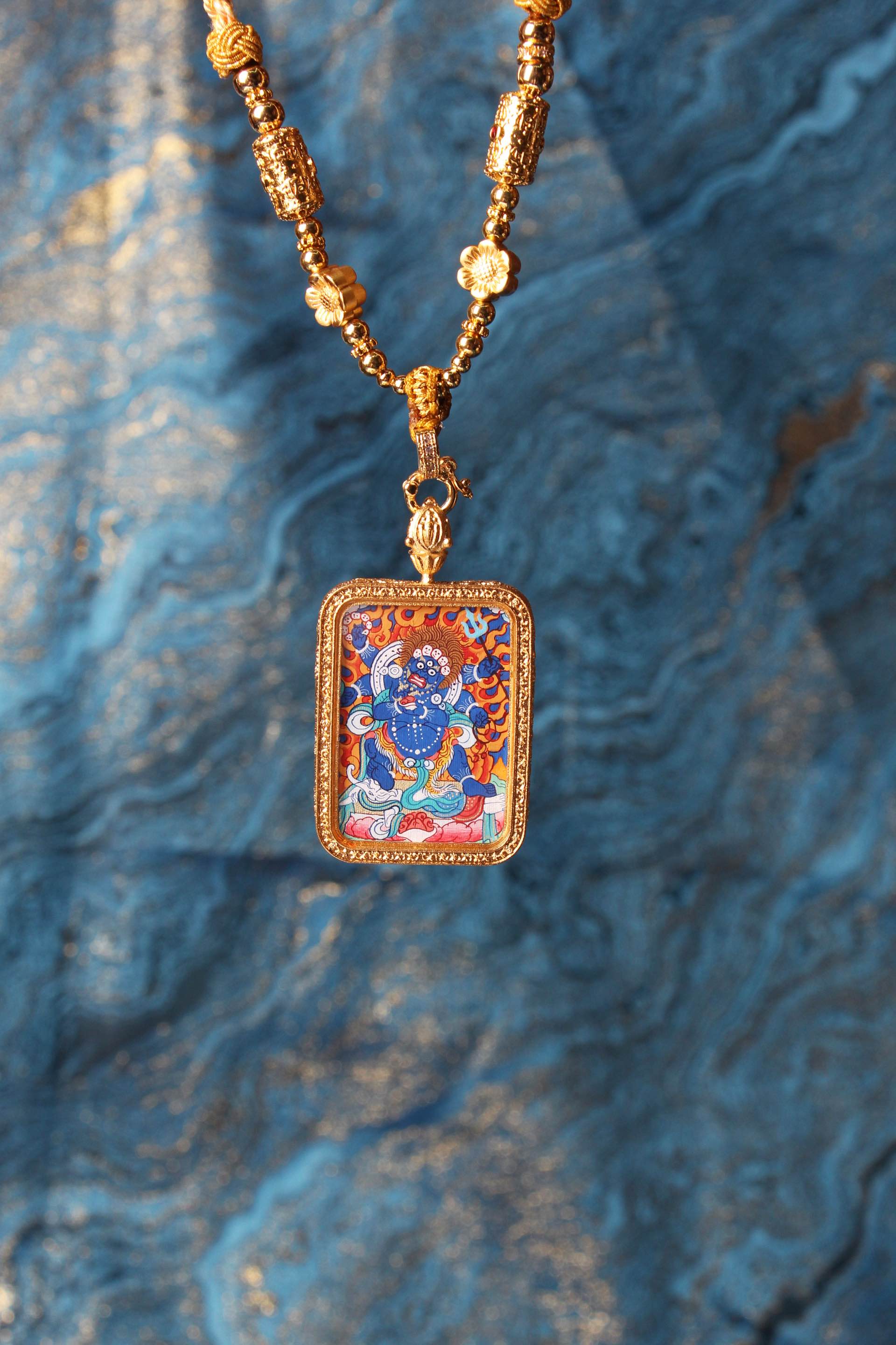 The Tibetan Buddhist Six-Armed Mahakala Thangka pendant displayed as a sacred protective amulet, embodying the fierce blessing and obstacle-removing power of Tibetan Buddhist tradition.