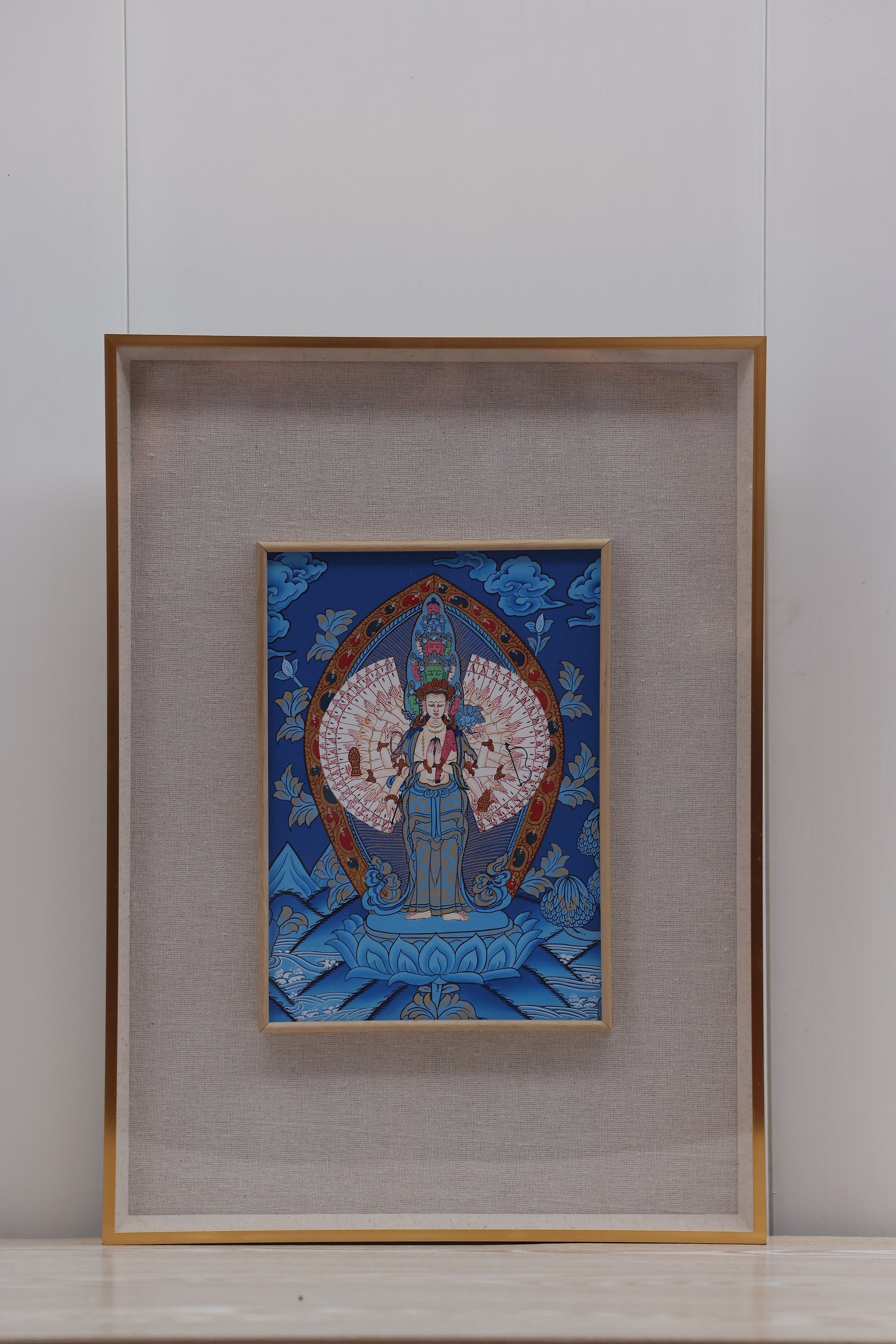 Tibetan Thangka of Thousand-Armed Thousand-Eyed Bodhisattva of Compassion, with intricate lotus flowers and celestial background.