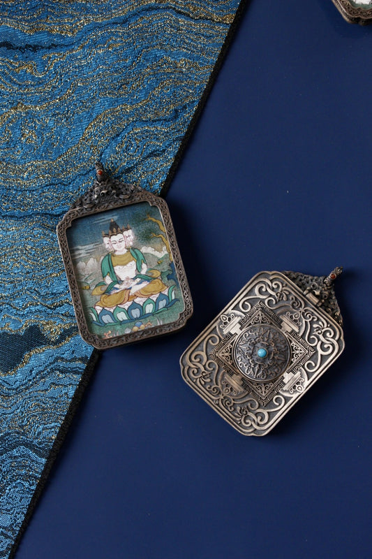 Tibetan Buddhist thangka pendant depicting Vairocana Buddha, symbolizing cosmic wisdom, universal truth, and enlightenment.