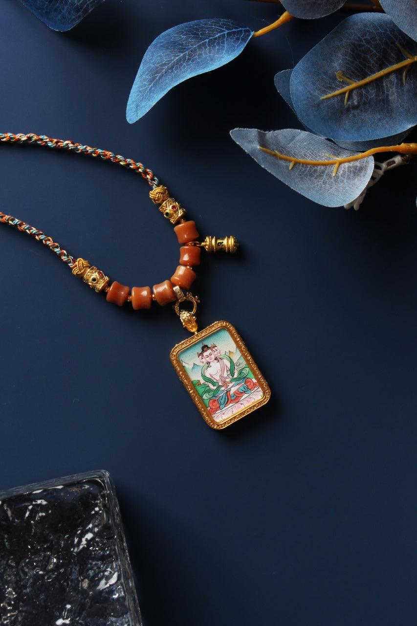 A 4x5cm hand-painted Karma Kagyu Vairocana Buddha Thangka pendant featuring the Buddha of Cosmic Light, encased in titanium steel, representing wisdom and clarity in Tibetan Buddhist tradition.

