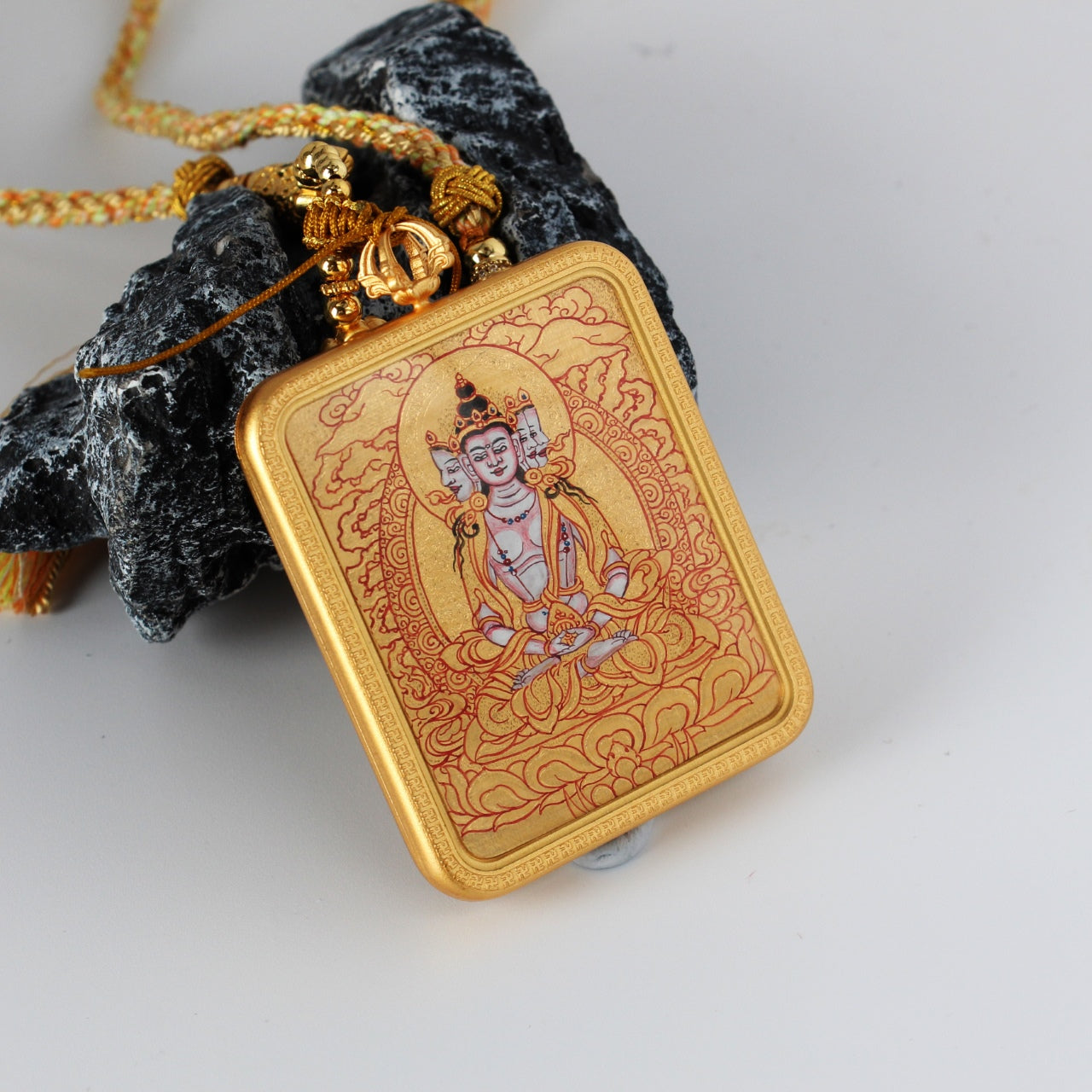  A 2.5x3.5cm hand-painted Karma Kagyu Four-Armed Avalokiteshvara Thangka pendant featuring the Bodhisattva of Great Compassion, encased in titanium steel, representing compassion in Tibetan Buddhist tradition.


