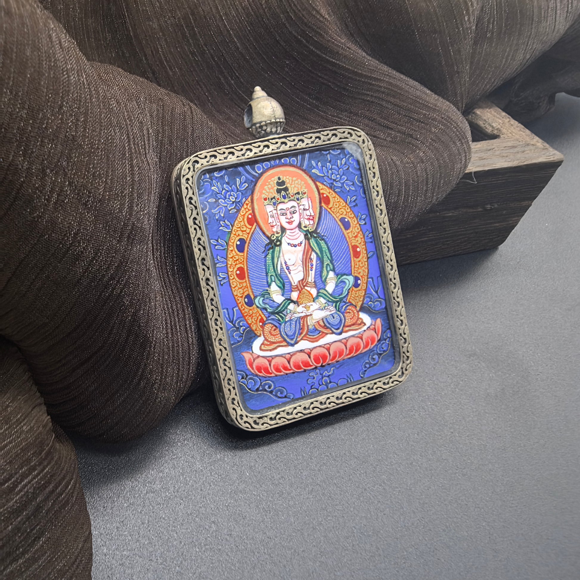  The Rekong Blue Thangka Vairocana pendant with 925 silver displayed as a sacred amulet for light and success, embodying Buddhist tradition.
