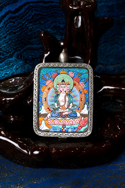 A sacred hand-painted Vairocana Buddha Thangka pendant from Regong, featuring the Buddha of Supreme Enlightenment in a fine silver frame.