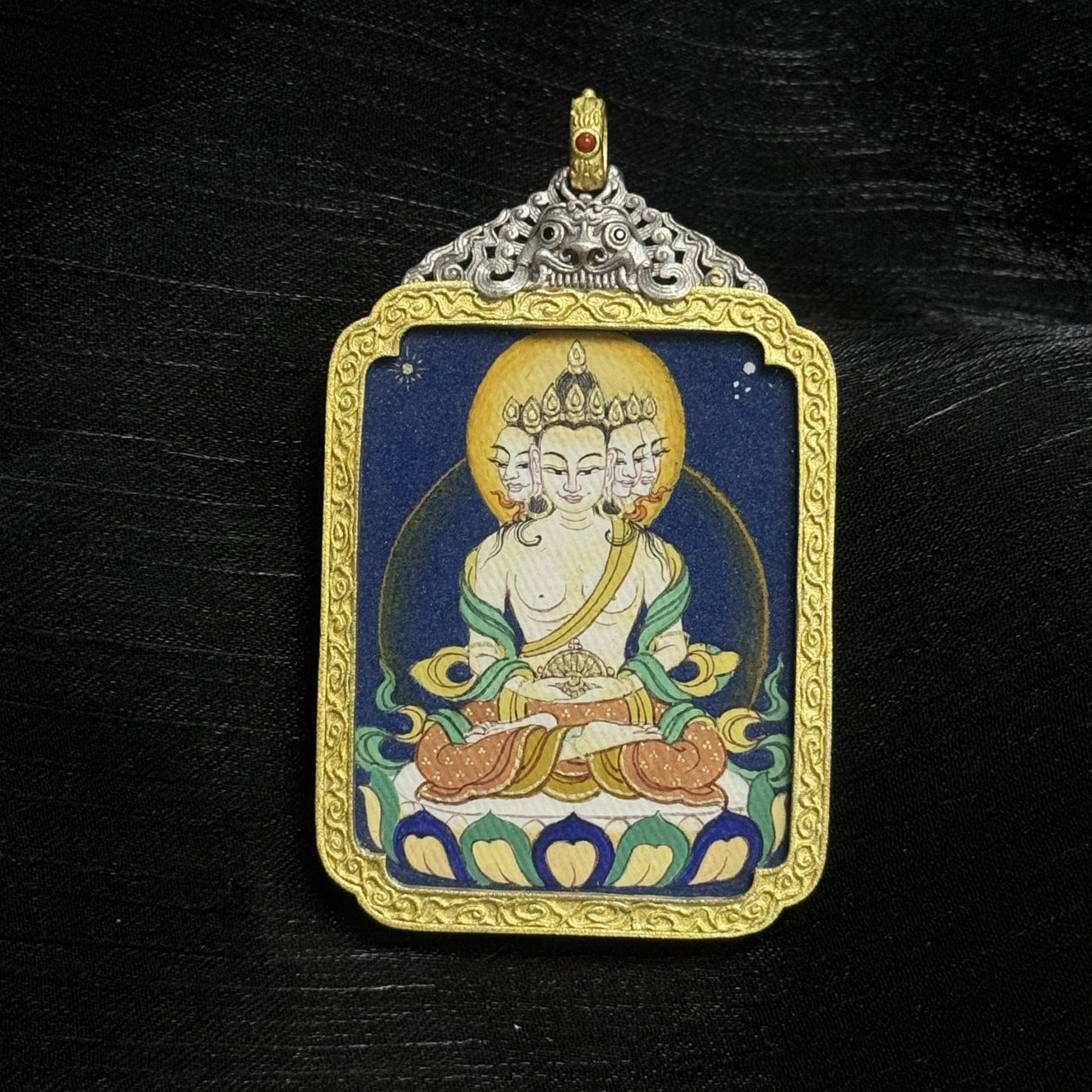 The Bold Vairochana Thangka pendant displayed as a sacred amulet for wisdom and success, embodying the cosmic light of Tibetan Buddhist tradition.

