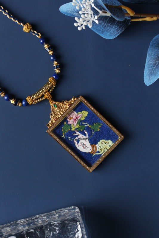  A 4x5cm hand-painted White Tara Buddha Hand Thangka pendant featuring the goddess of longevity and compassion, encased in titanium steel, representing healing and longevity in Tibetan Buddhist tradition.
