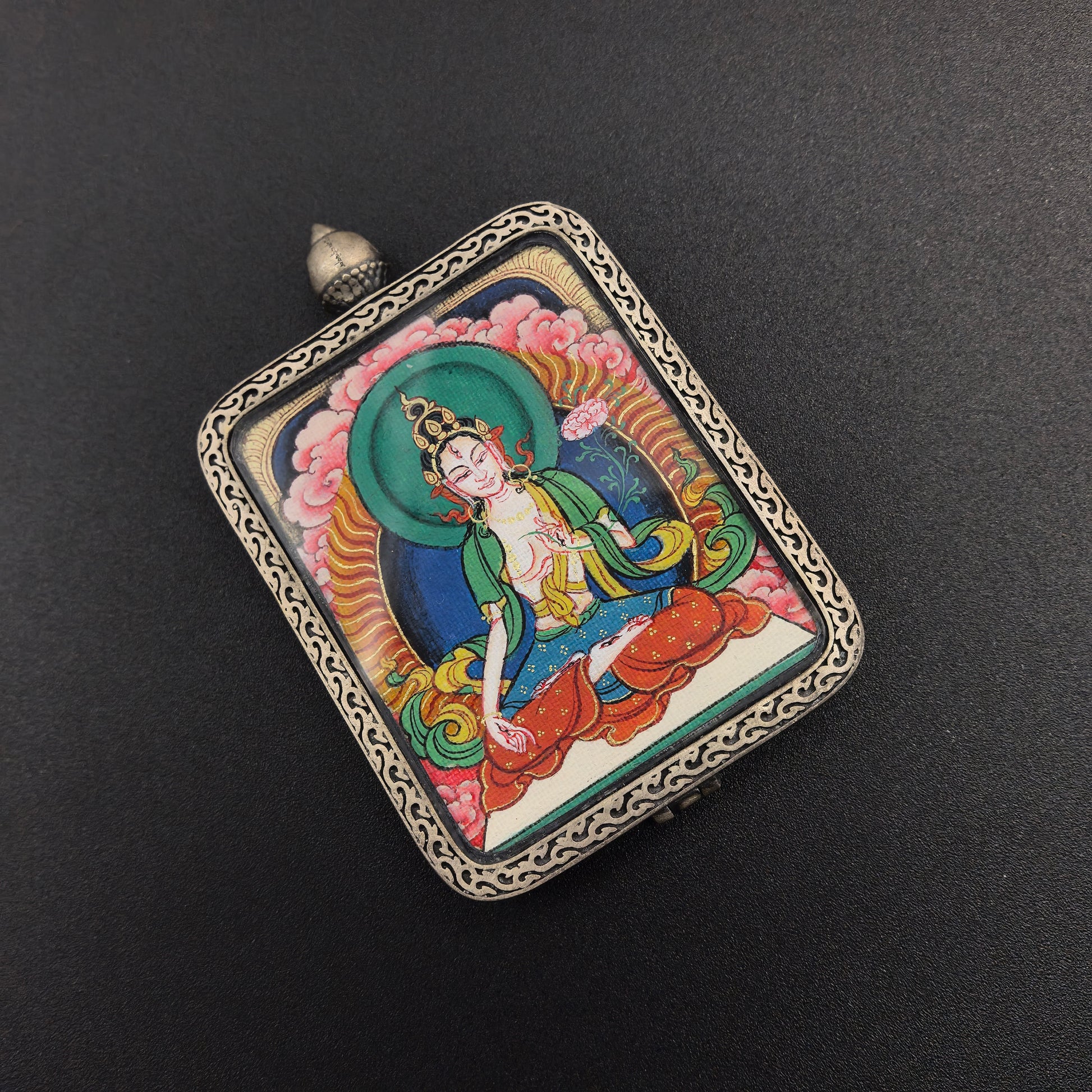 The Tibet Red Cloud White Tara Thangka pendant with 925 silver displayed as a sacred amulet for longevity and wisdom, embodying Buddhist tradition.
