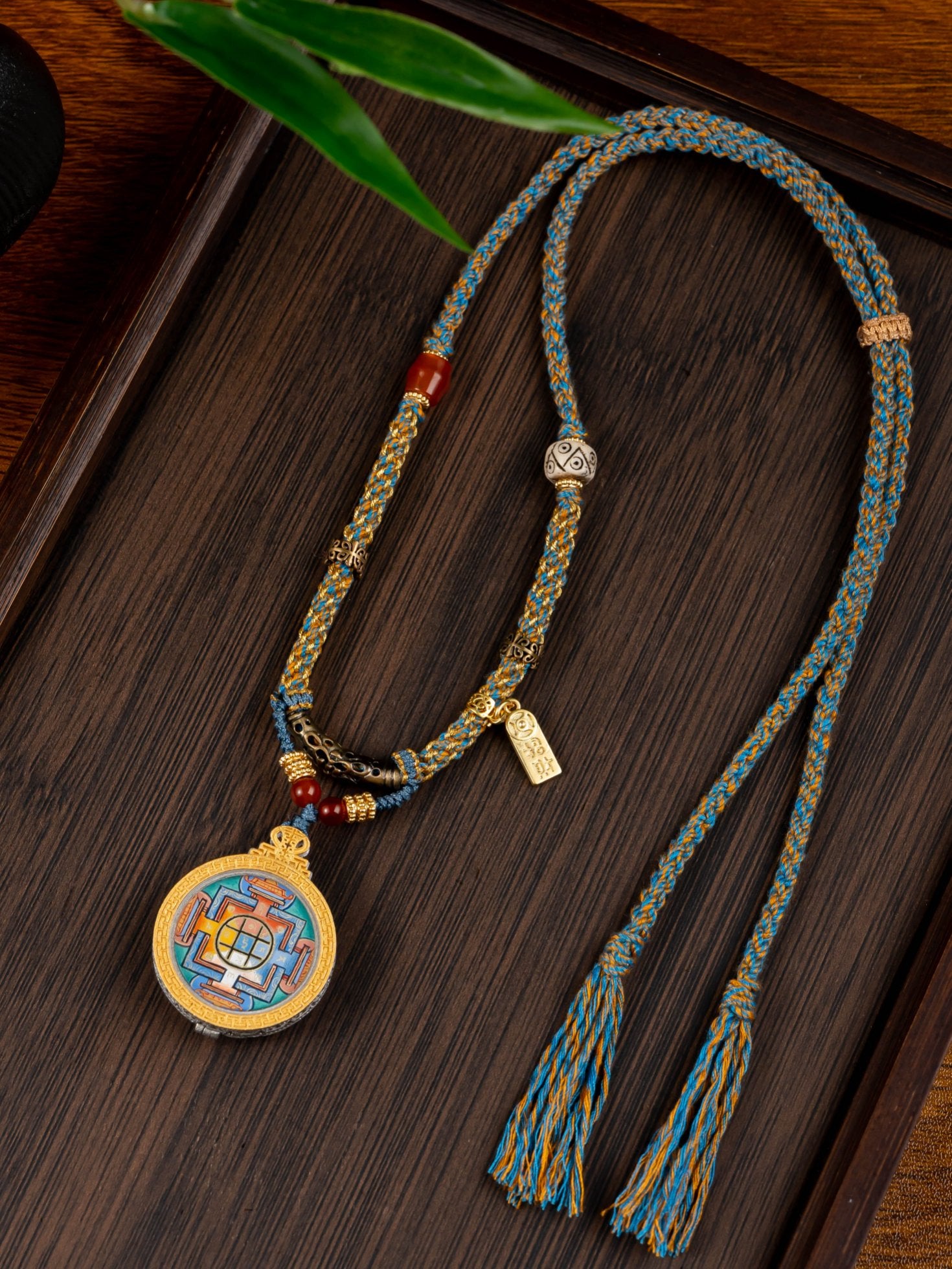  The Rekong Yamantaka Mandala Thangka pendant with copper tube braided cord displayed as a sacred amulet for protect wholesomeness and awaken wisdom, embodying Buddhist tradition.

