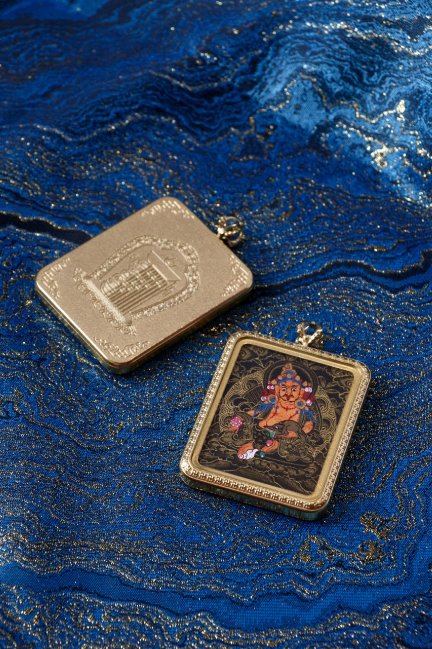 Yellow Jambhala thangka pendant depicting the Tibetan Buddhist wealth deity, symbolizing prosperity, generosity, and abundance.