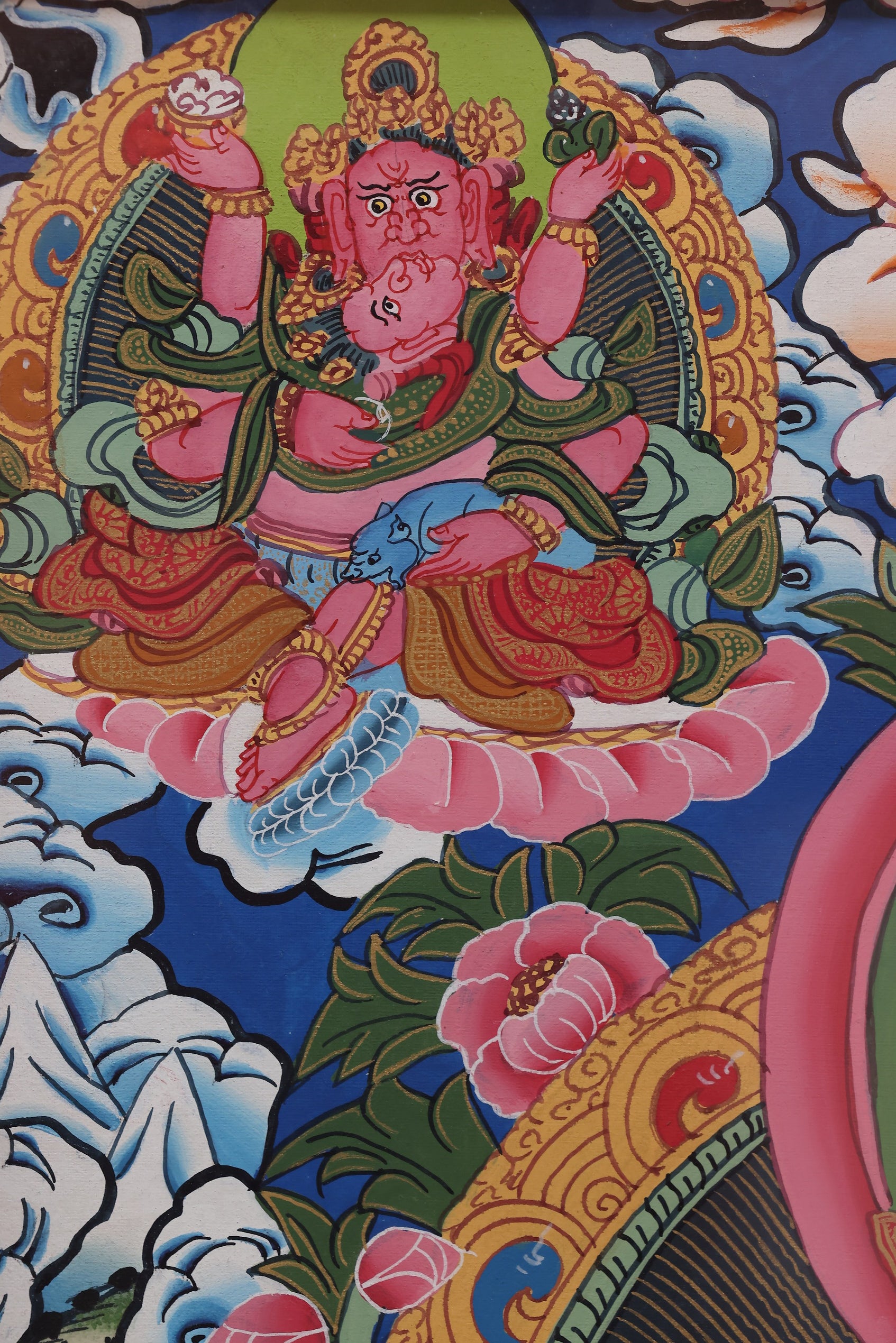 Yellow Jambhala seated on a dragon lotus, emphasizing spiritual power and material prosperity.