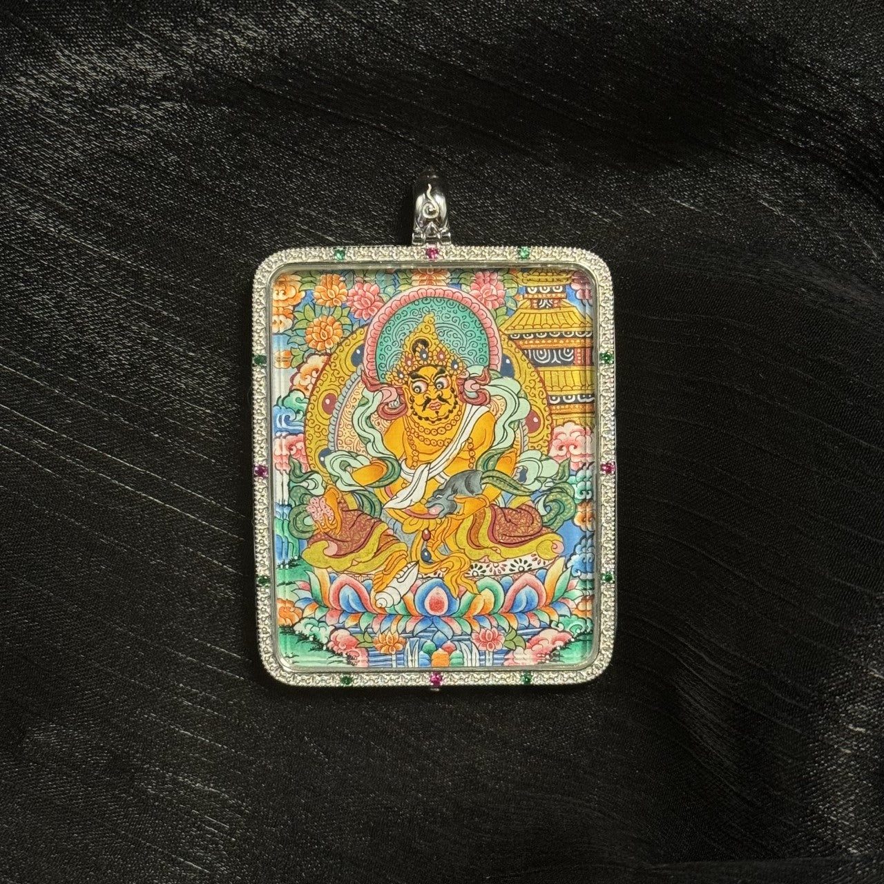  A 4x5cm hand-painted Yellow Jambhala with Mandala Thangka pendant featuring the chief of wealth deities, representing right wealth and career in Tibetan Buddhist tradition.
