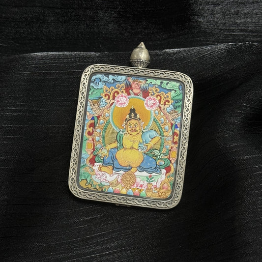  A 4x5cm hand-painted Menri-style Yellow Jambhala Thangka pendant featuring the wealth deity, encased in 925 silver with Dunhuang Nine-Colour Deer design, symbolising fortune and abundance in Tibetan Buddhist tradition.
