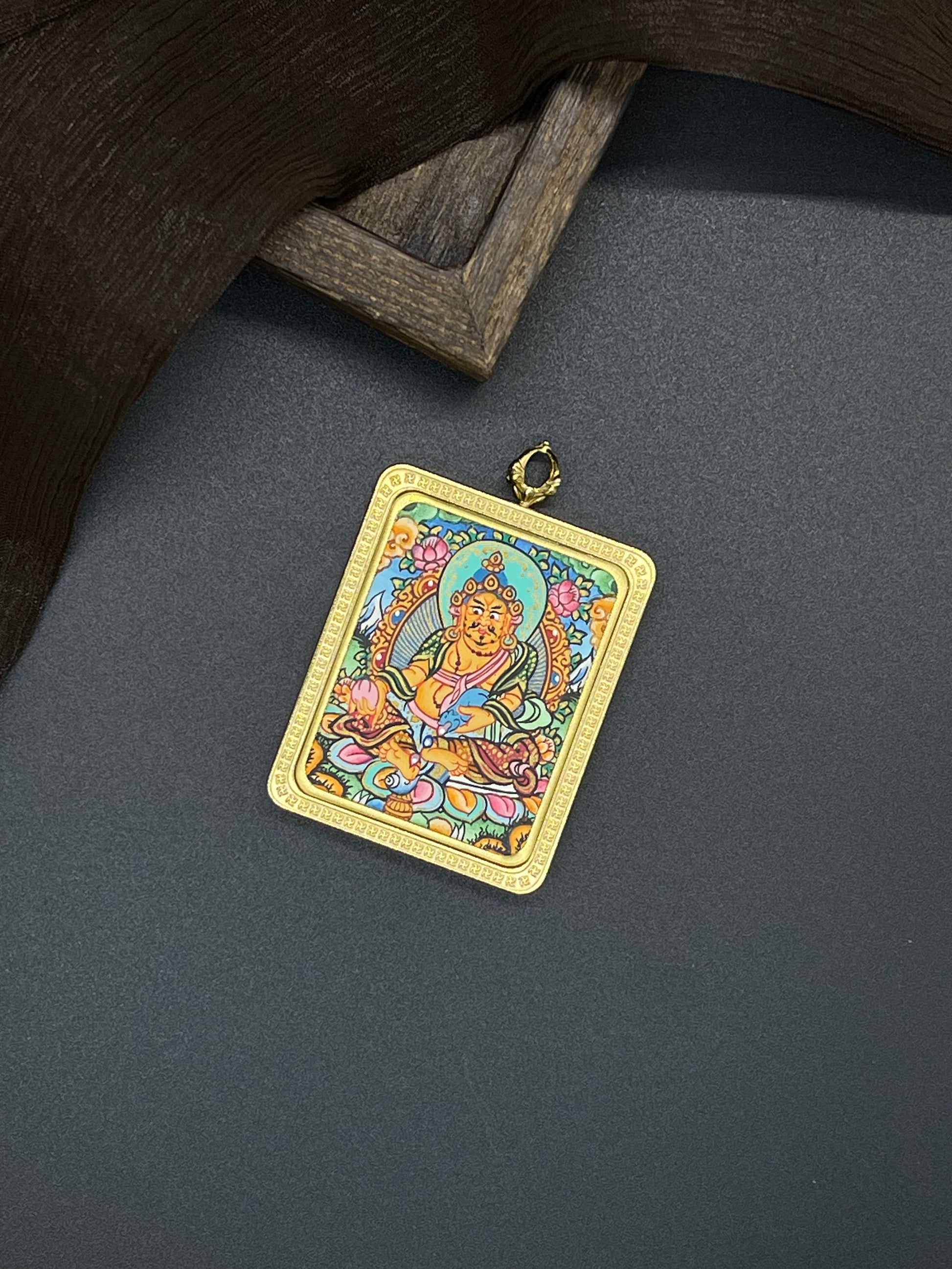 Hand-painted Nepal Yellow Jambhala (黄财神) Thangka pendant 3.5x4.5cm with titanium casing featuring the chief of wealth deities, representing the bestowal of prosperity in Buddhist tradition.
