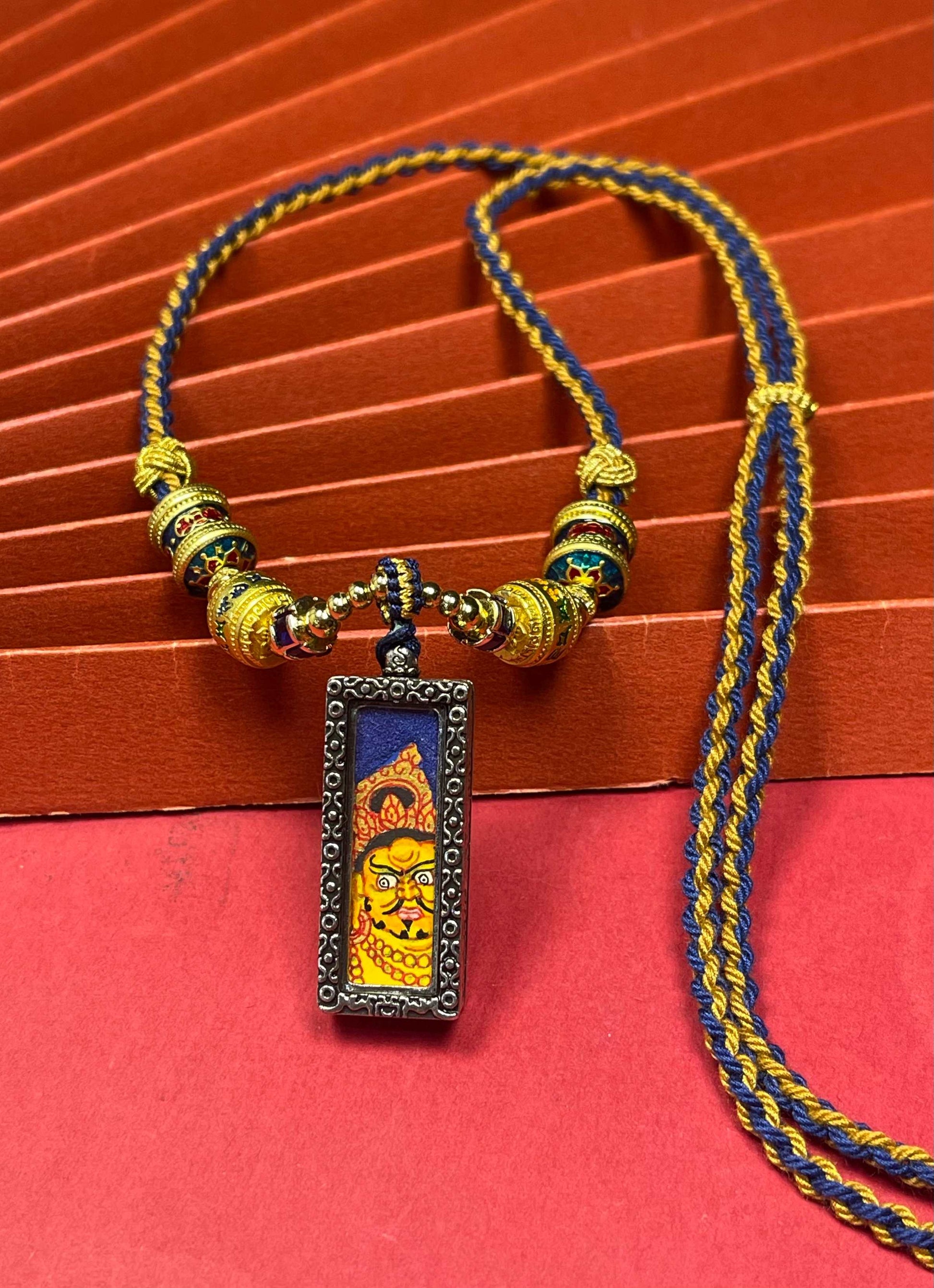  Detailed view of the silver copper casing for the Yellow Jambhala Thangka pendant, symbolising wealth and tradition in Buddhist practice.
