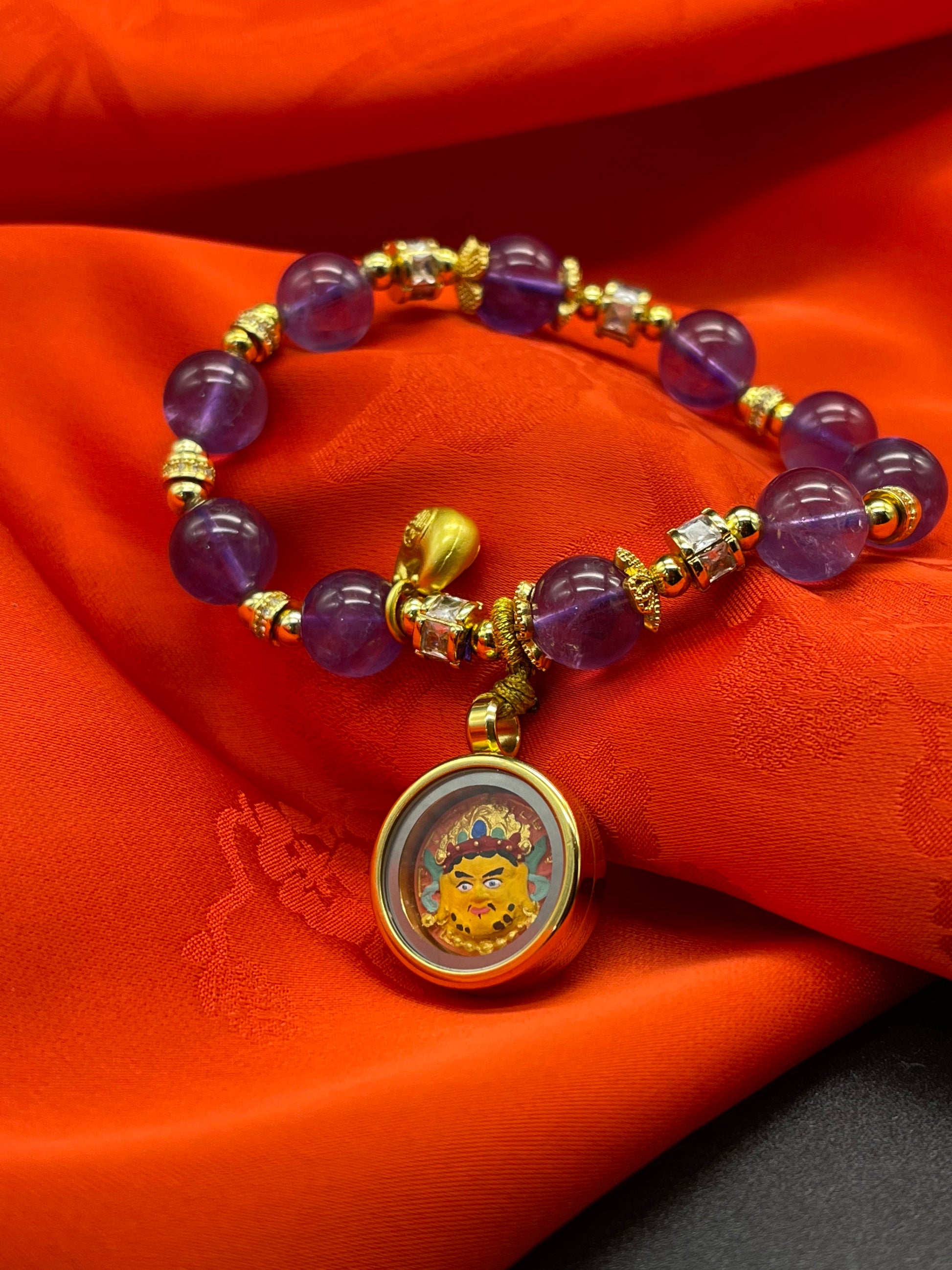  Detailed view of the amethyst bracelet and Yellow Jambhala tsa-tsa set, symbolising wealth and tradition in Buddhist practice.
