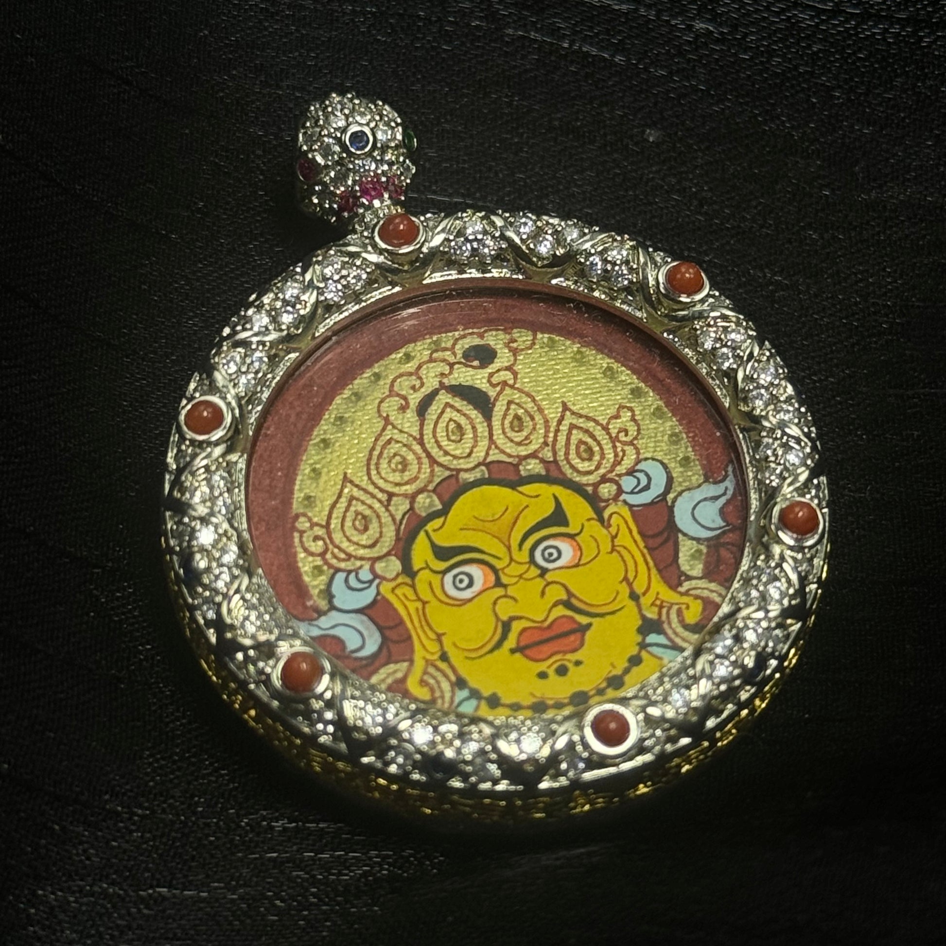  The Rekong Red-Gold Yellow Jambhala Buddha Head Thangka pendant displayed as a sacred amulet for wealth and career, embodying Buddhist tradition.
