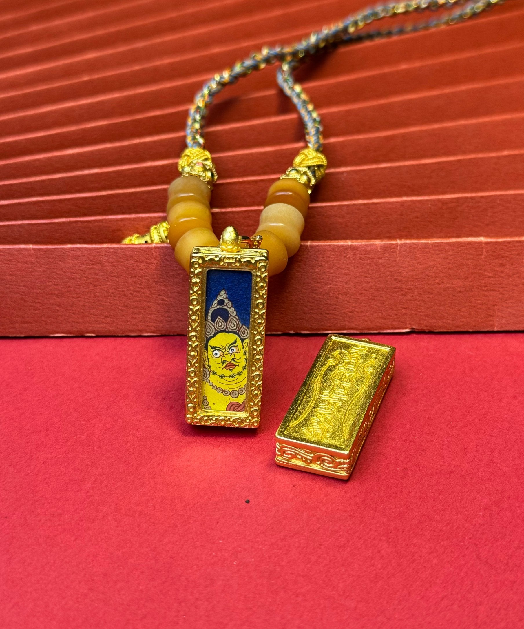 Hand-painted Rekong Yellow Jambhala (黄财神) Thangka pendant 1x3 inch with copper casing featuring the king of wealth deities, representing prosperity in Buddhist tradition.
