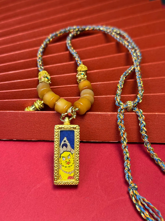  Detailed view of the refined copper casing for the Yellow Jambhala Thangka pendant, symbolising wealth and tradition in Buddhist practice.
