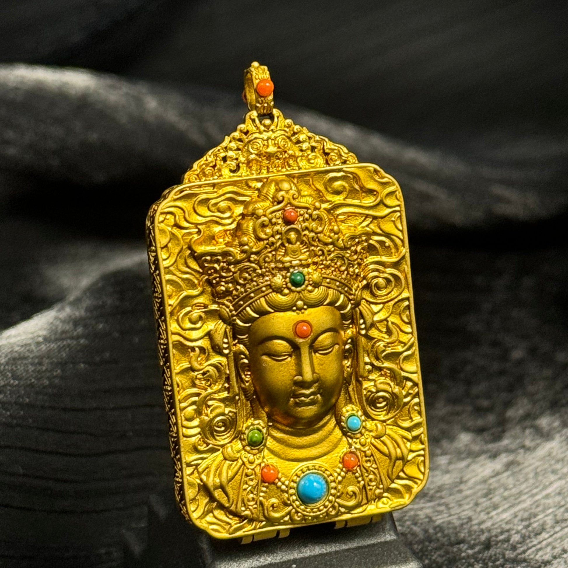 The Rekong Yellow Jambhala Thangka pendant displayed as a sacred amulet for wealth and blessing, embodying Buddhist tradition.
