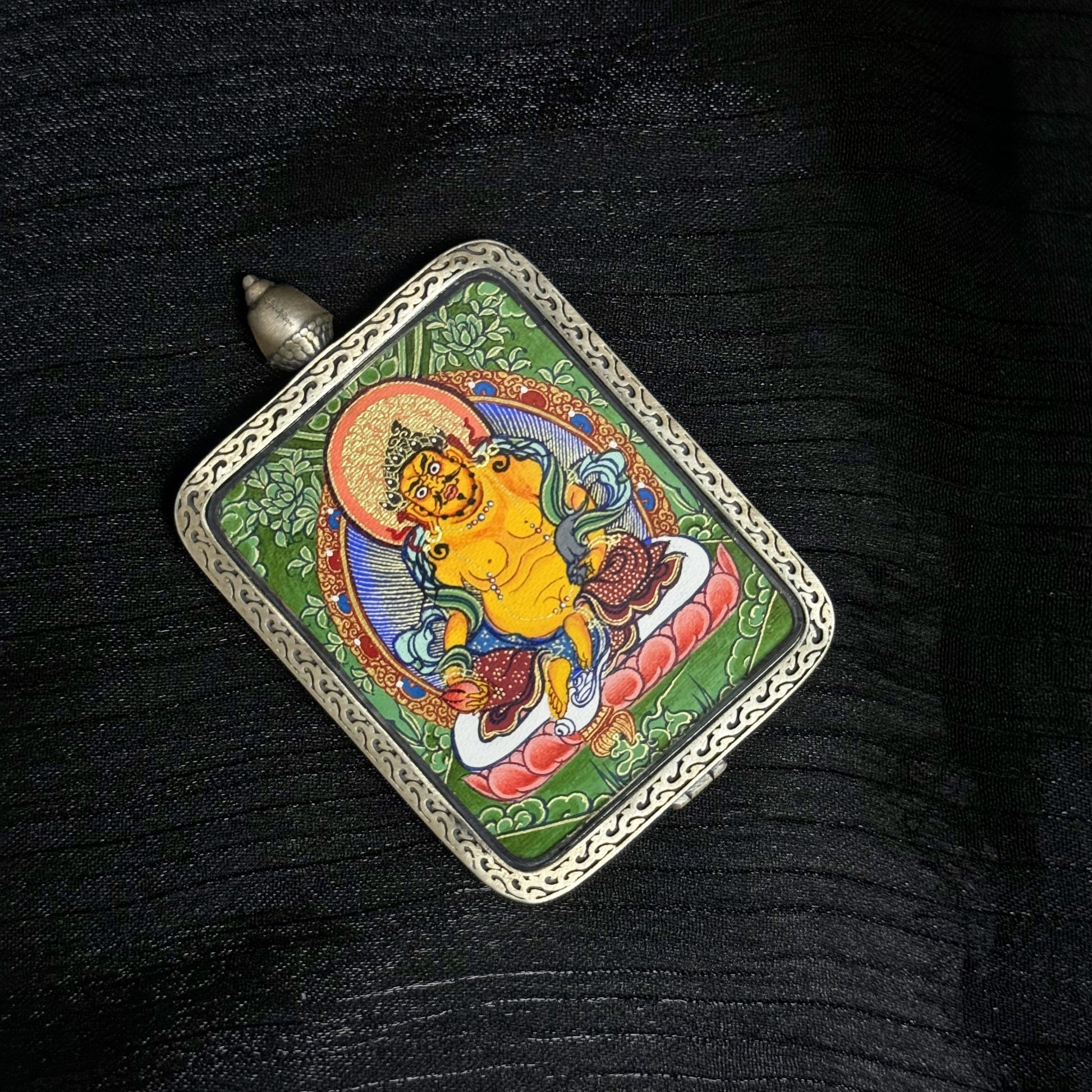  Detailed view of the presentation and casing for the Yellow Jambhala Cuiying Thangka pendant.
