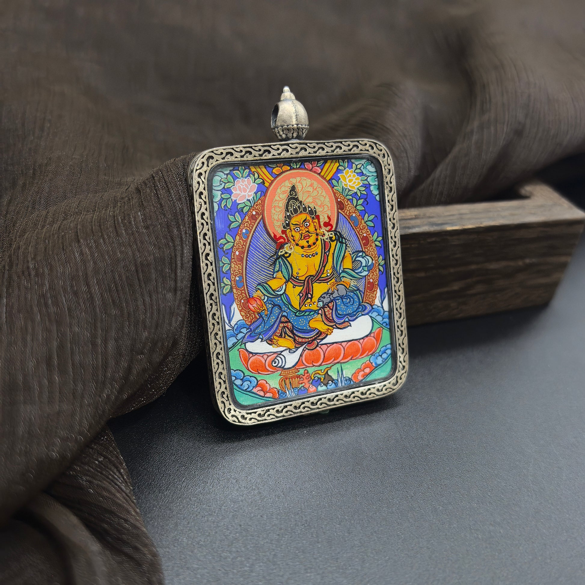 The Rekong Yellow Jambhala pendant with 925 silver displayed as a sacred amulet for wealth and fortune, embodying Buddhist tradition.
