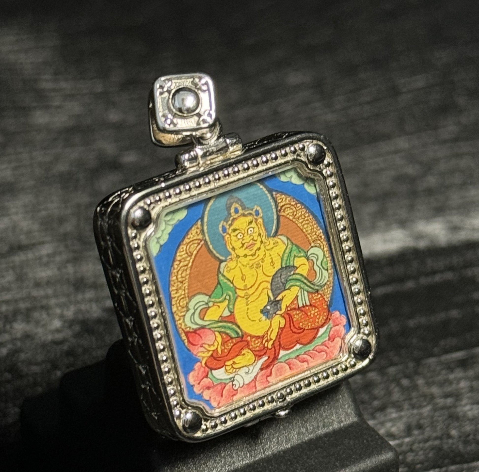 Detailed view of the protective casing for the Yellow Jambhala Thangka pendant, symbolising protection and tradition in Buddhist practice.

