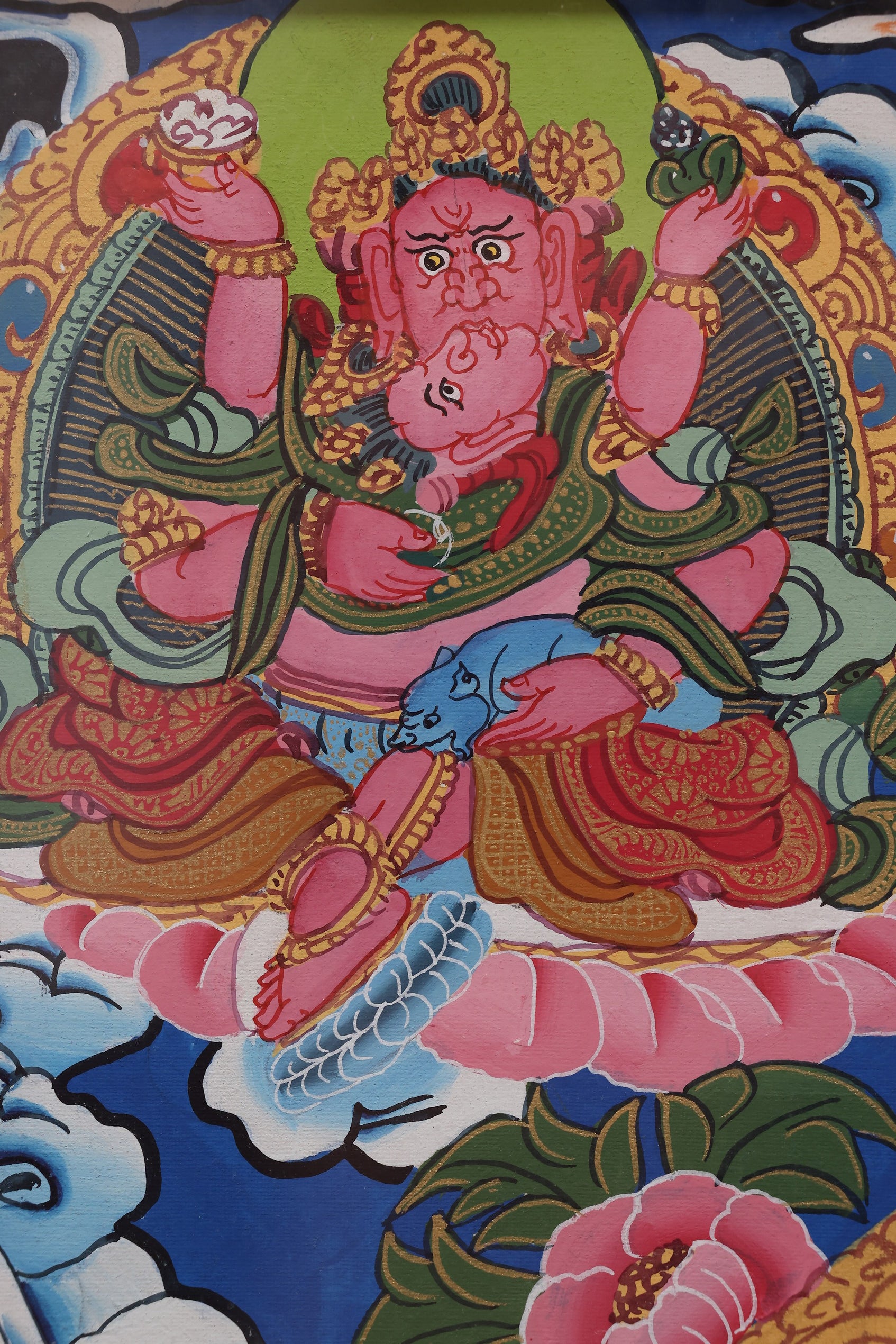 Yellow Jambhala holding a ruyi scepter and treasure vase, symbolizing wealth and fulfillment.