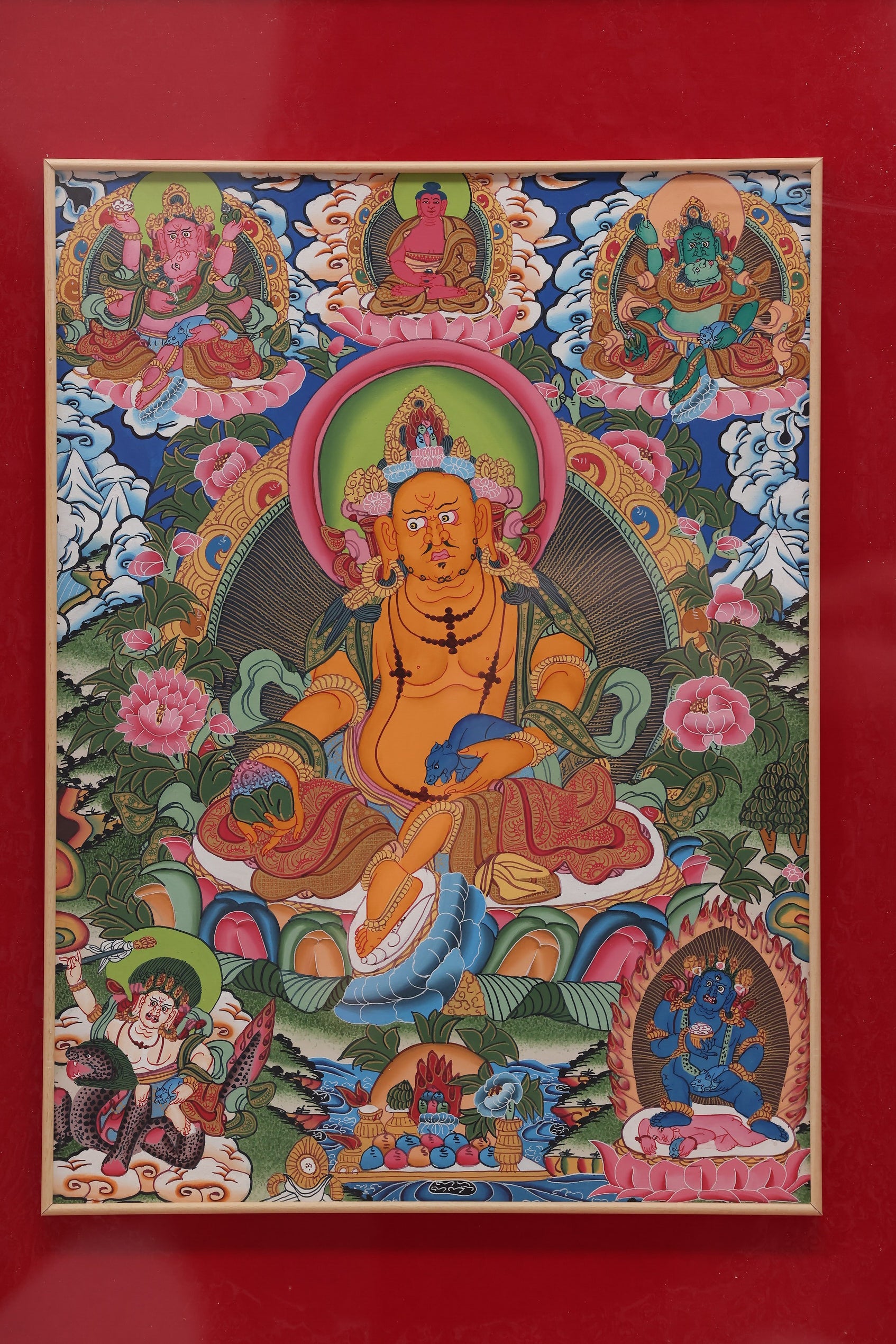 Yellow Jambhala holding a treasure vase, depicted in a traditional Tibetan Buddhist Thangka.