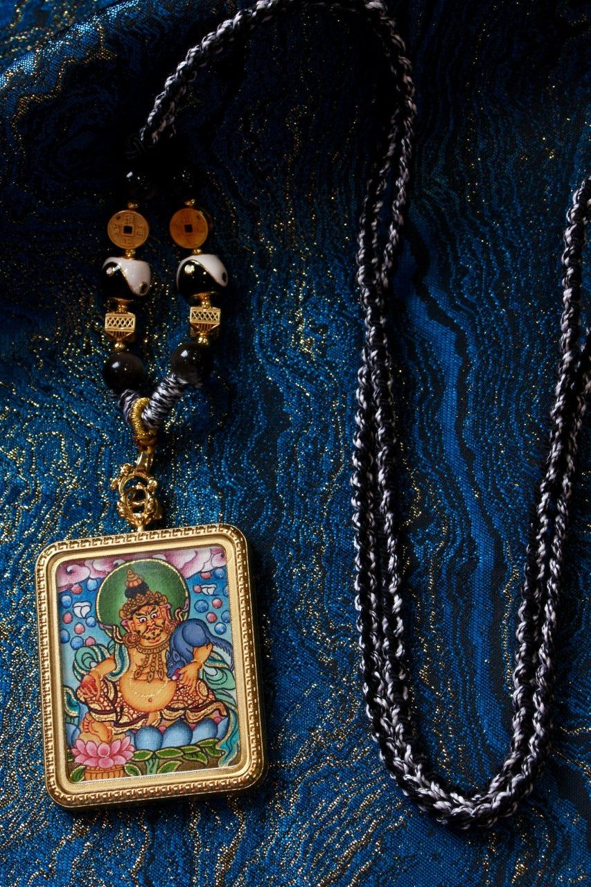 Yellow Jambhala Thangka Amulet, a powerful symbol of wealth and prosperity in Tibetan Buddhism.