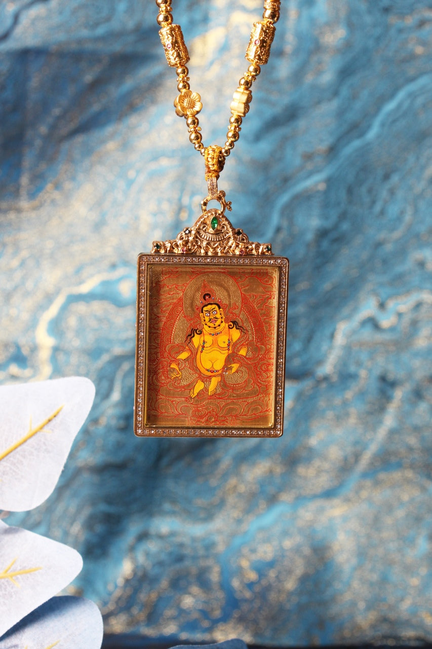 The Tibetan Buddhist Yellow Jambhala Thangka pendant displayed as a sacred amulet for wealth and prosperity, embodying the blessing of abundance in Tibetan Buddhist tradition.
