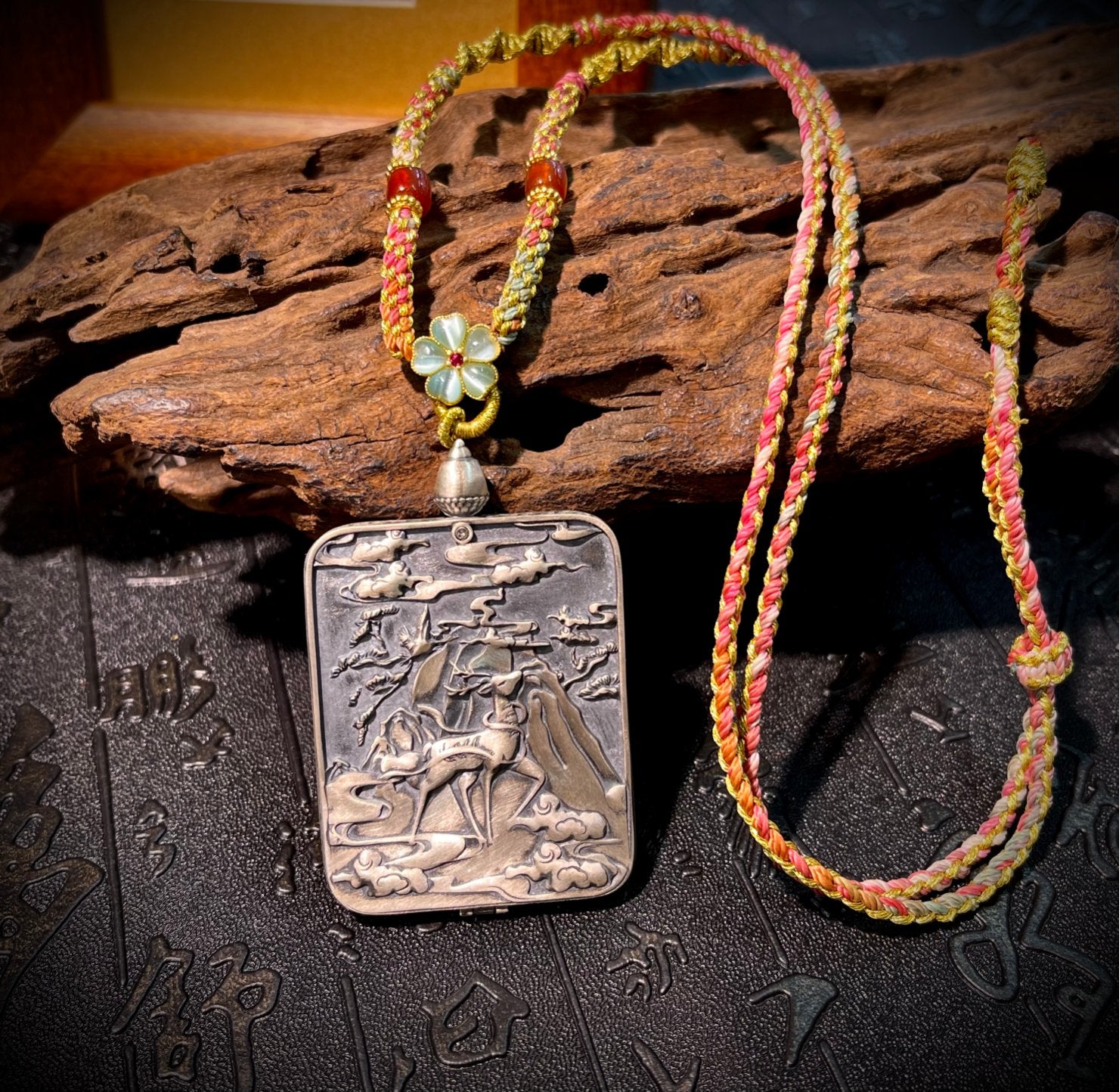 The Tibet Yellow Jambhala Thangka pendant with Dunhuang Nine-Color Deer silver casing displayed as a sacred amulet for wealth and liberation from poverty, embodying Buddhist tradition.
