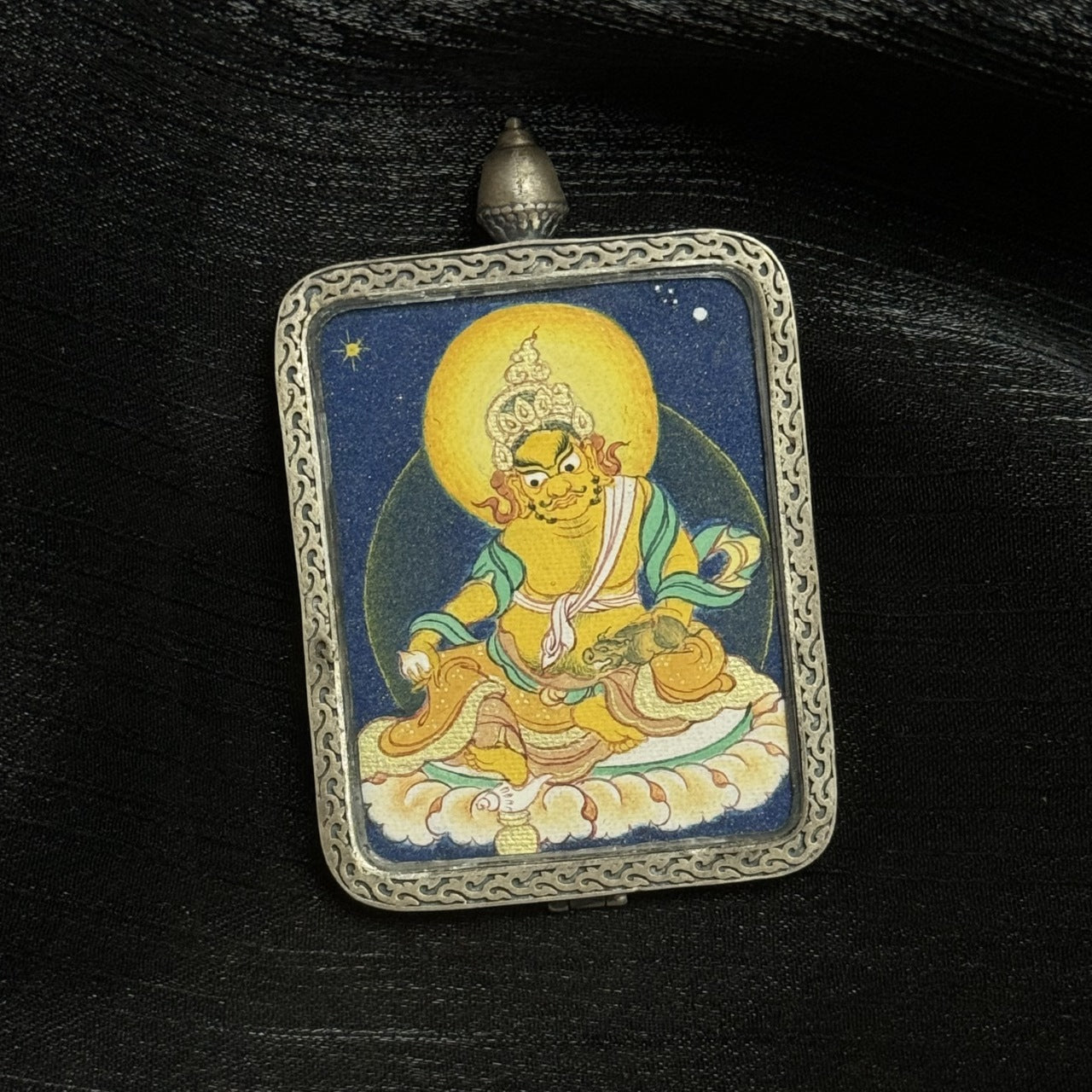  The Tibet Coarse Yellow Jambhala Thangka pendant displayed as a sacred amulet for wealth and Dharma, embodying Tibetan Buddhist tradition.
