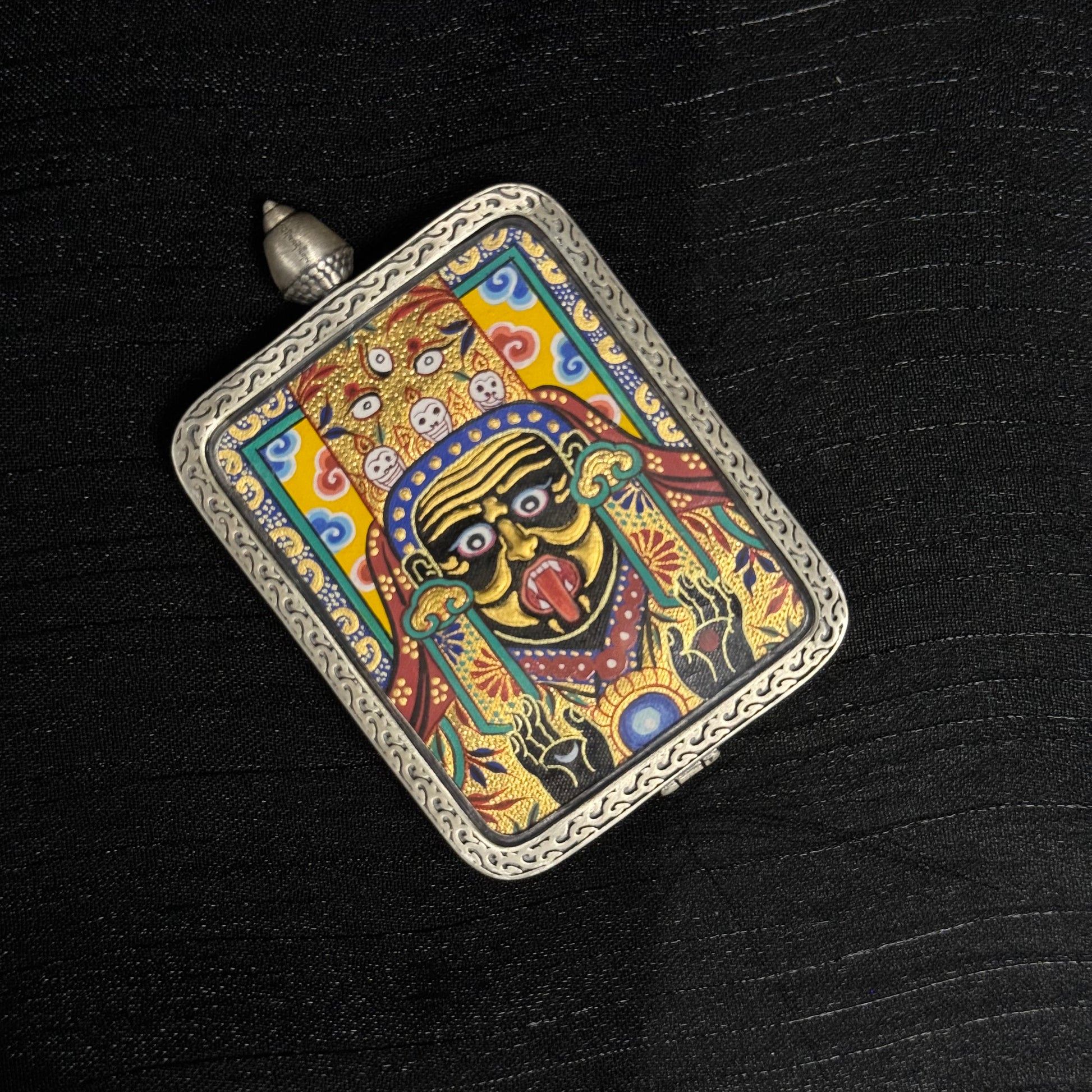The Rekong Zaki Lhamo Gold Relief Thangka pendant with 925 silver casing displayed as a sacred amulet for wealth and blessing.
