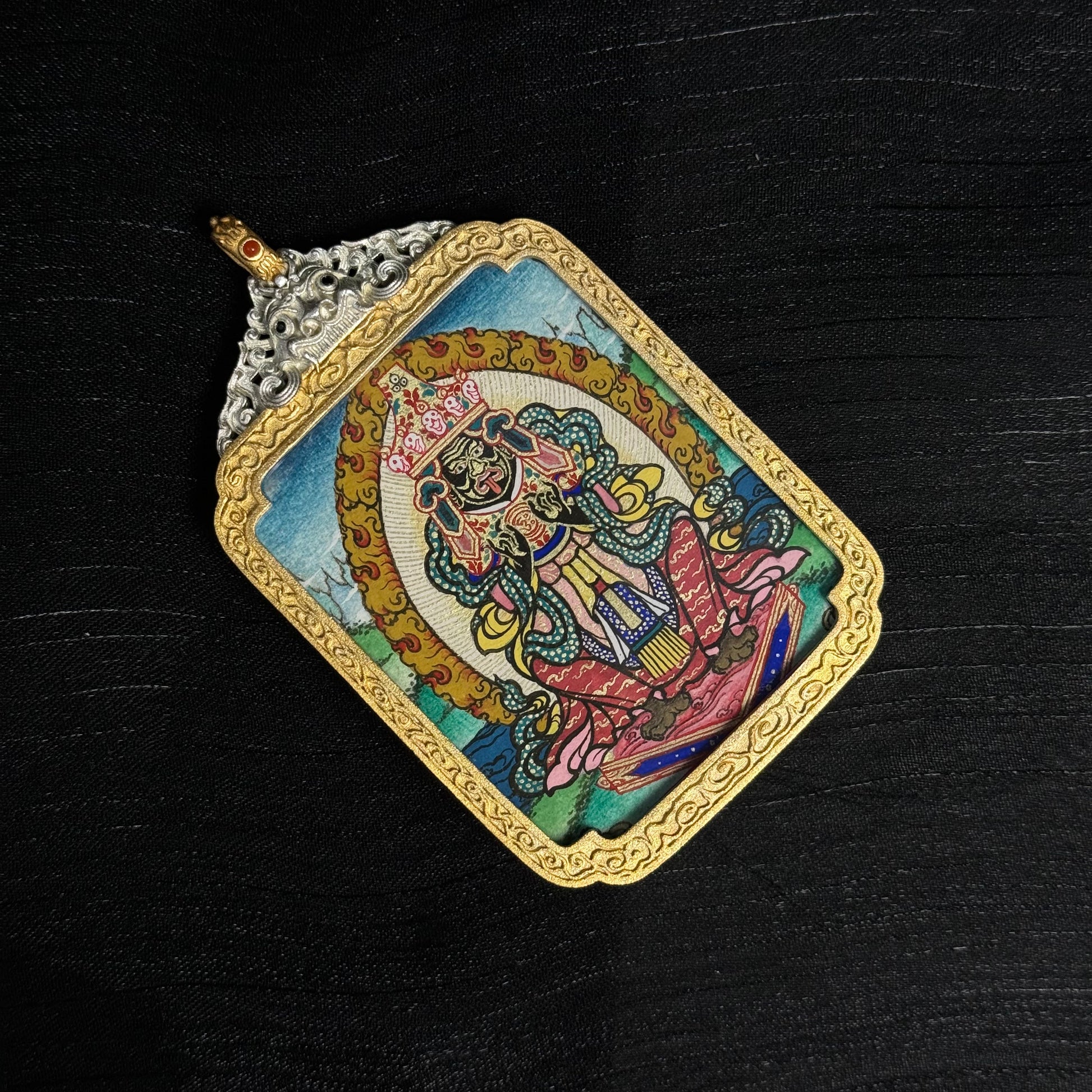 The Rekong Zaki Lhamo premium Thangka pendant displayed as a sacred amulet for wealth and blessing.

