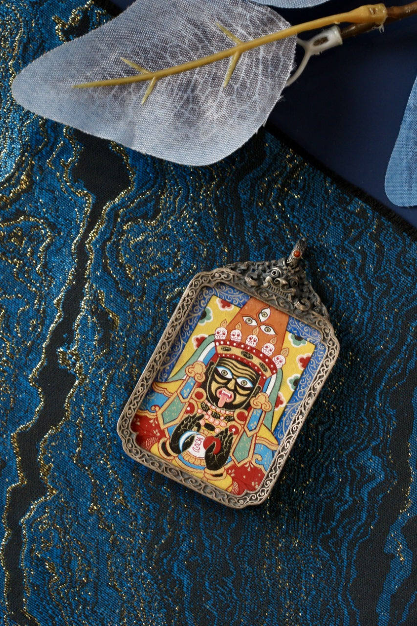 Tibetan Buddhist art thangka pendant showing Zaki Lhamo, symbolizing fortune, protection, and prosperity in Tibetan culture.