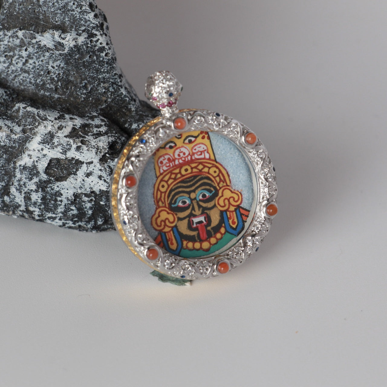 The Nepal Rough Zhagilamu Thangka pendant displayed as a sacred amulet for wealth and protection, embodying Tibetan Buddhist tradition.
