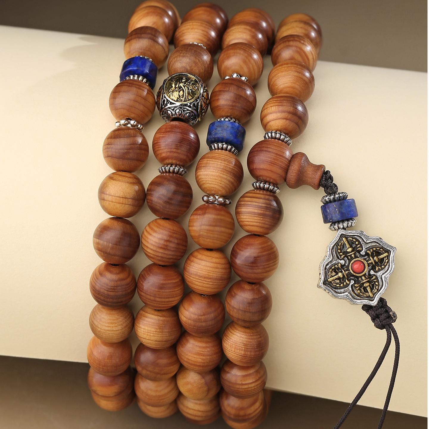 Tibetan Buddhist cypress mala featuring lapis beads and brass deity elements, crafted for meditation and protection.