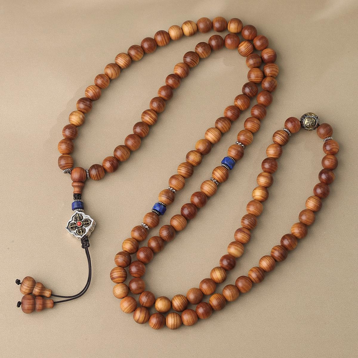 Tibetan mala with cypress beads and brass deity bead symbolizing wealth, blessing, and inner strength.