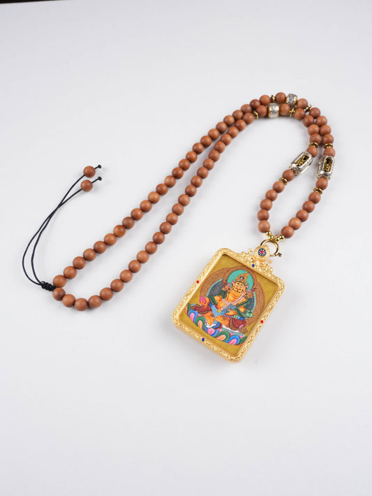 Hand-painted Tibetan Thangka pendant of Yellow Jambhala, the Buddhist Wealth Deity bringing prosperity and abundance.