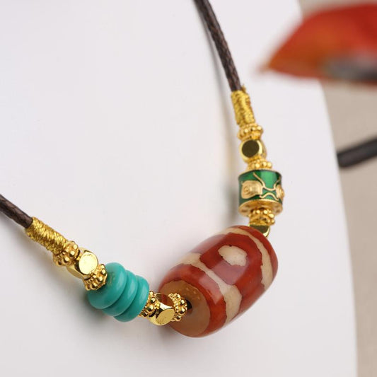 Spiritual Mala necklace featuring a Red Three-Eyes Dzi bead, a symbol of protection and positive energy in Tibetan culture.