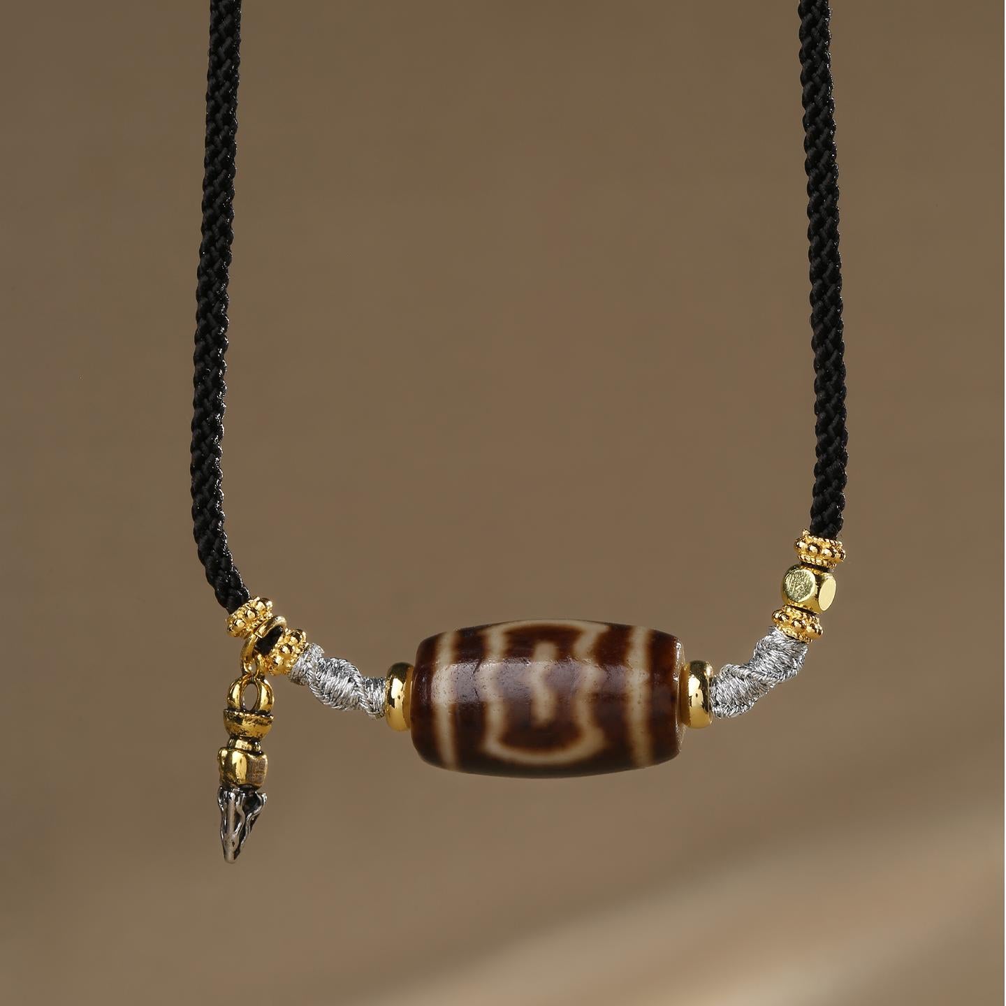 Handmade Tibetan Buddhist Garuda Dzi agate necklace symbolizing protection and power.