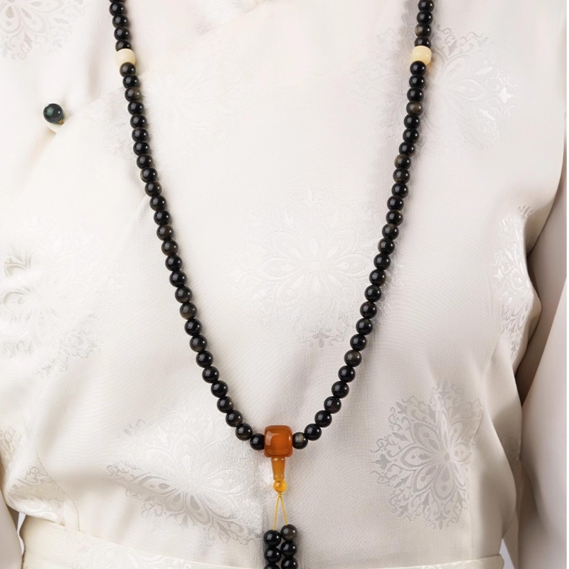 Golden obsidian meditation mala with 108 beads, Tibetan spiritual jewelry design.