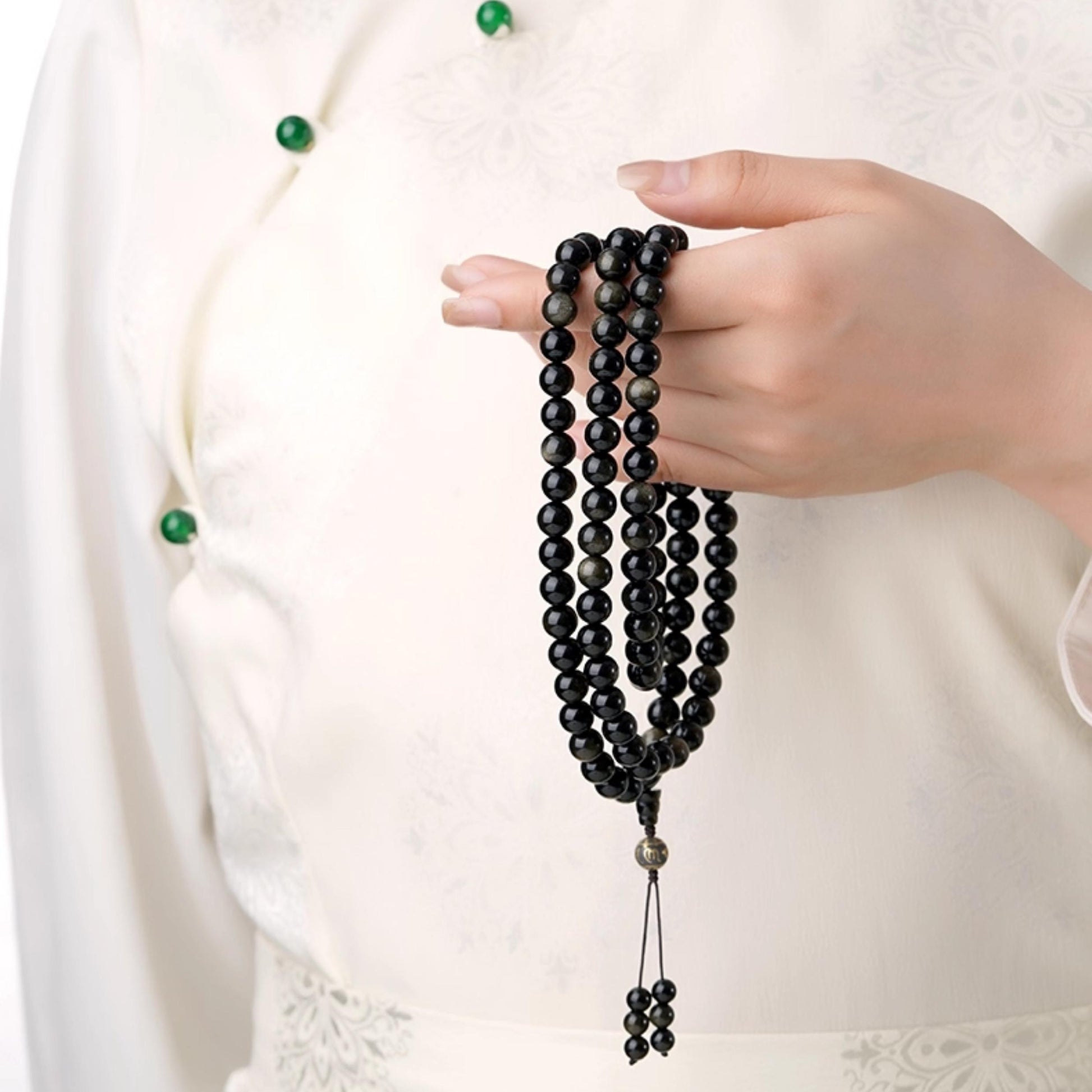 Tibetan Buddhist mala with obsidian beads and ash mantra elements, artisan-made.