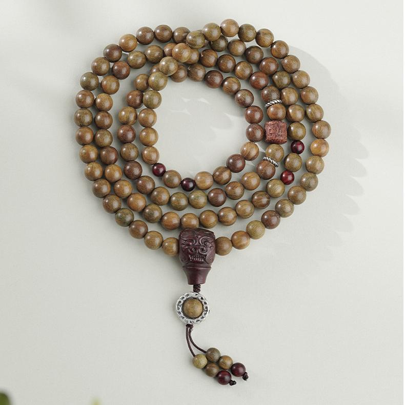 Handmade Tibetan Buddhist green sandalwood bead bracelet with bloodwood and silver accents.