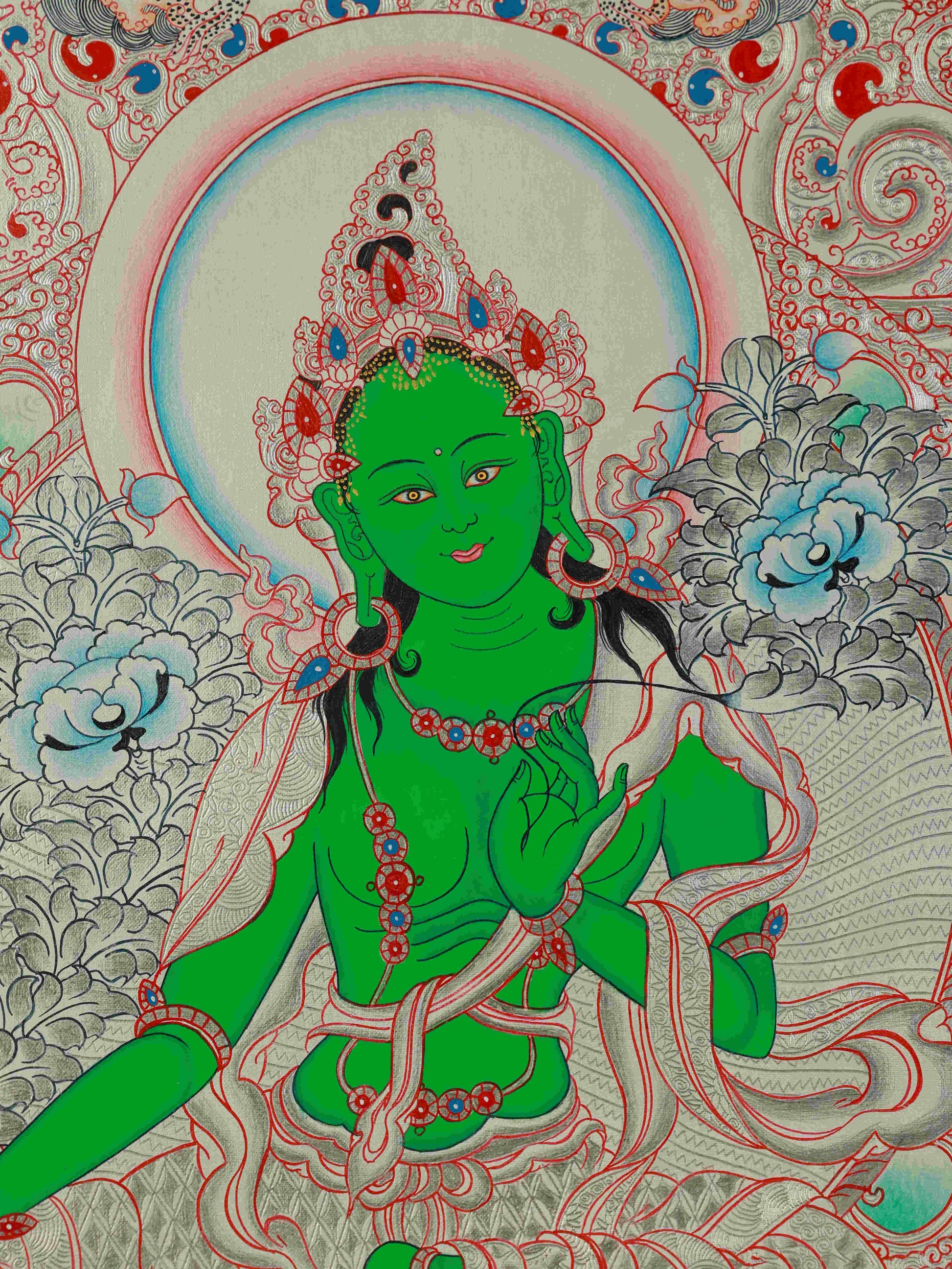 Tibetan Thangka painting of Green Tara with silver foil highlights, symbolizing compassion and protection.