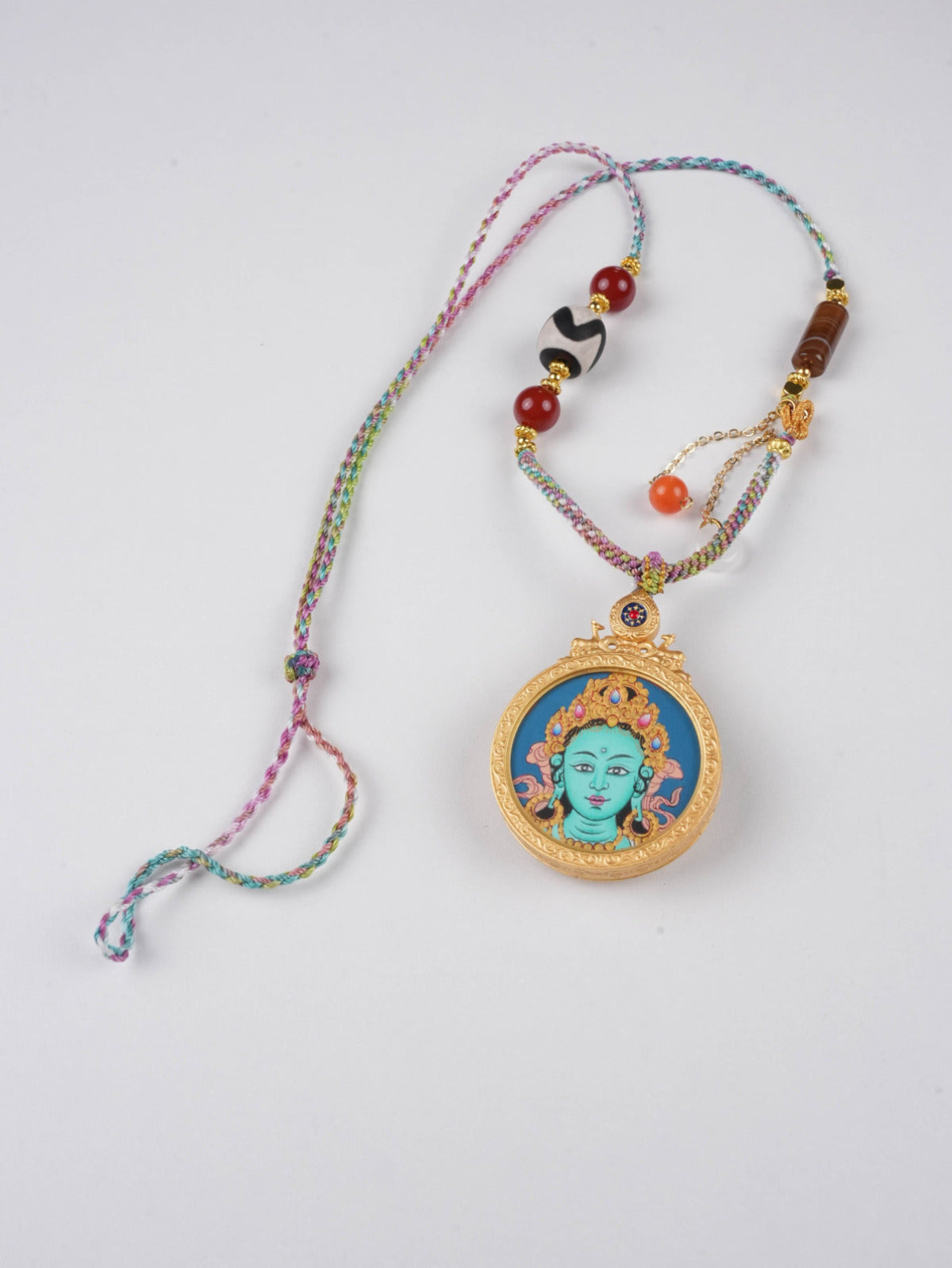 Round Tibetan Gau pendant with Green Tara, the Mother of Enlightened Action.