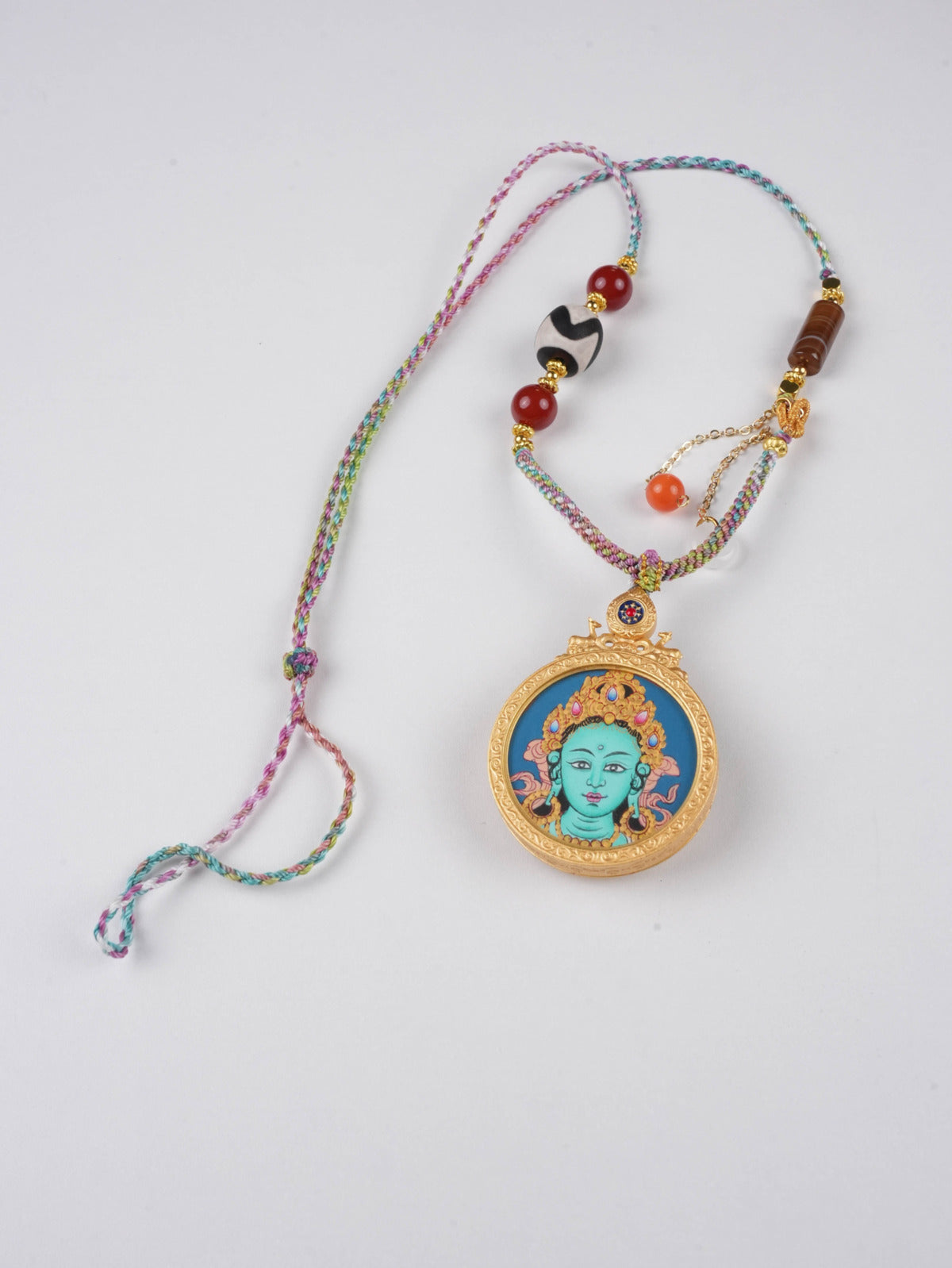 Hand-painted Tibetan Thangka pendant depicting Green Tara, goddess of protection and health.