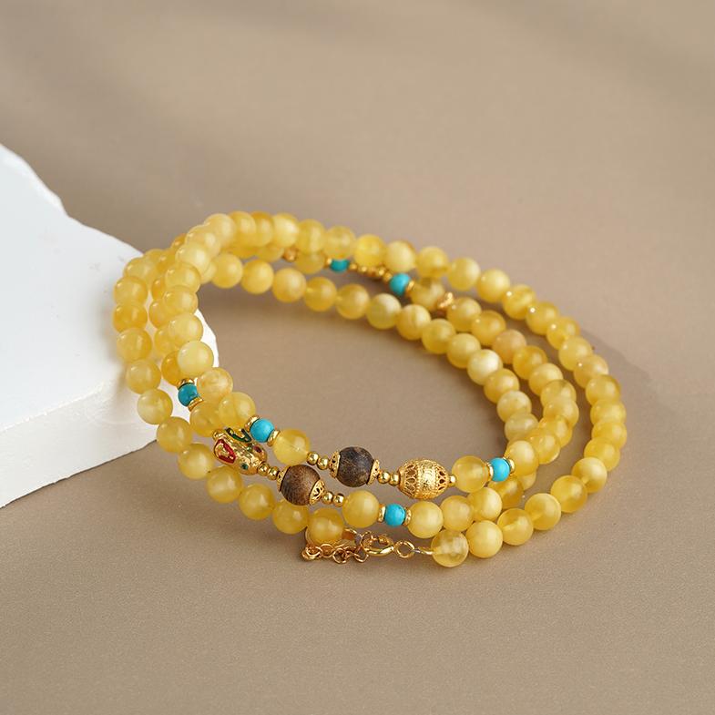 Handmade Tibetan Buddhist amber and agarwood necklace with silver Buddha pendant and sacred art details.