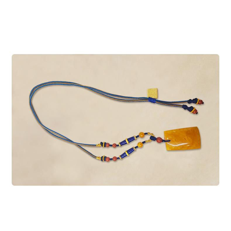 Artisan Tibetan amber necklace with symbolic lapis and silver details.