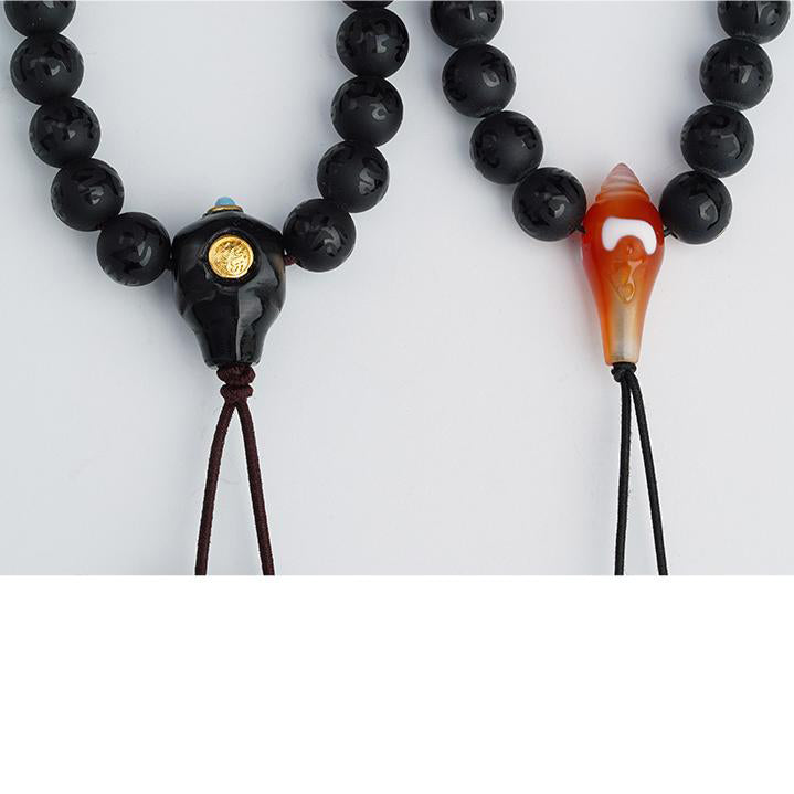 Obsidian Tibetan mala featuring agate three-way connector and dzi bead.